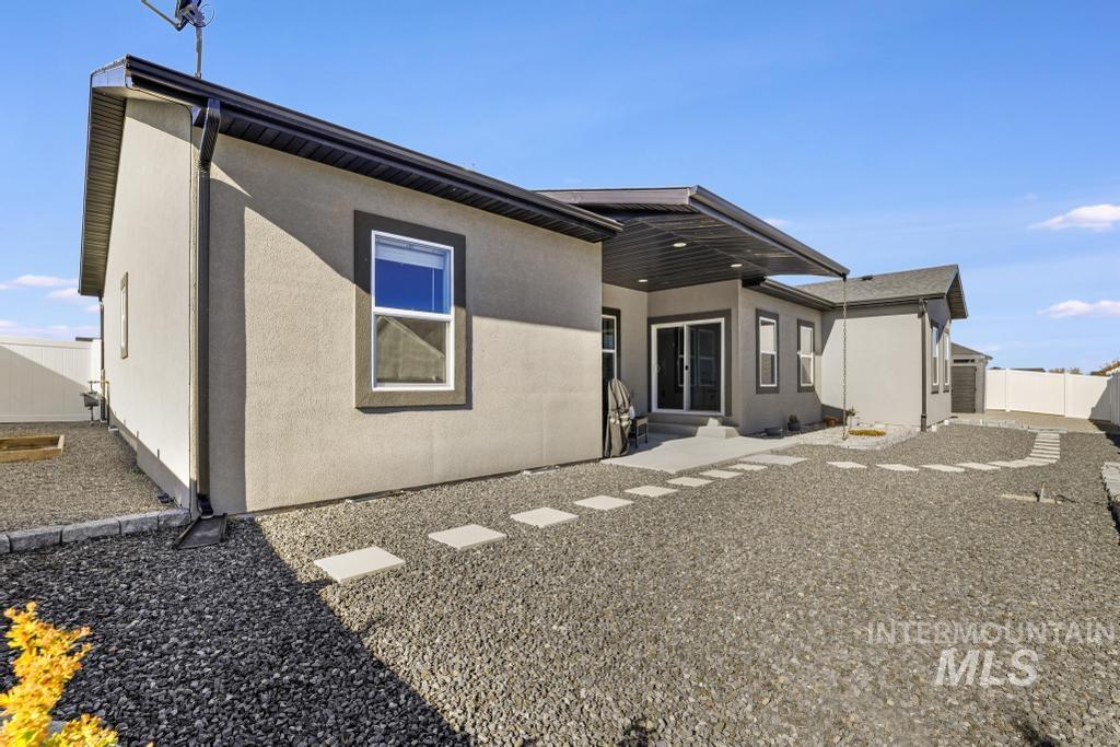 Back of property featuring a fenced backyard and stucco siding