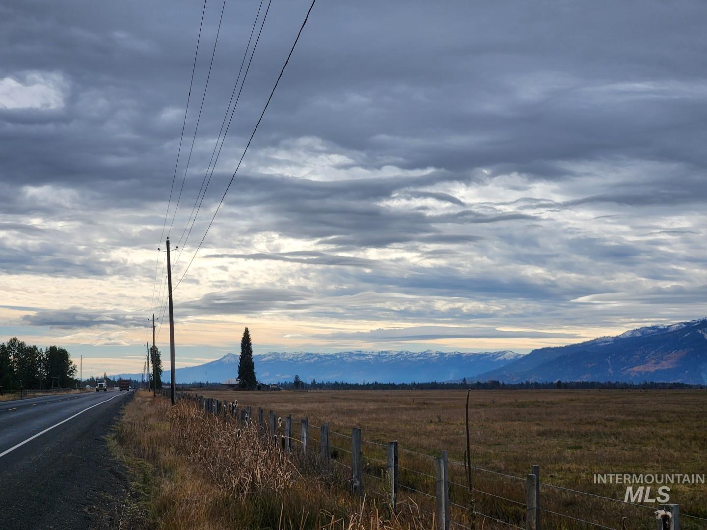 View of asphalt road featuring a view of rural / pastoral area and a mountain view