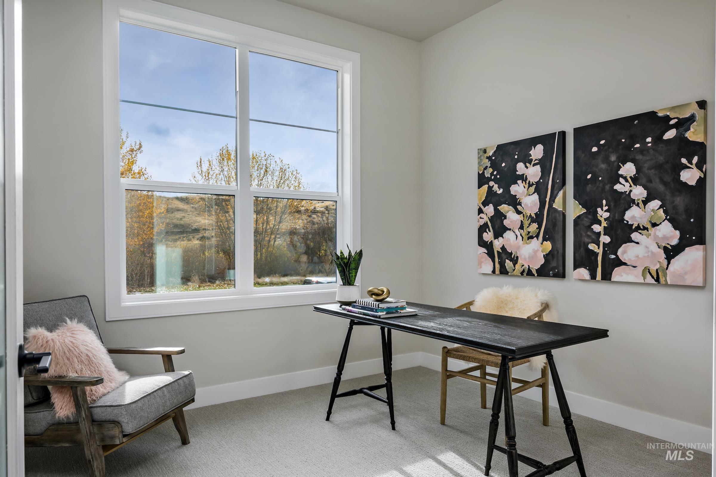 Office with light colored carpet and baseboards