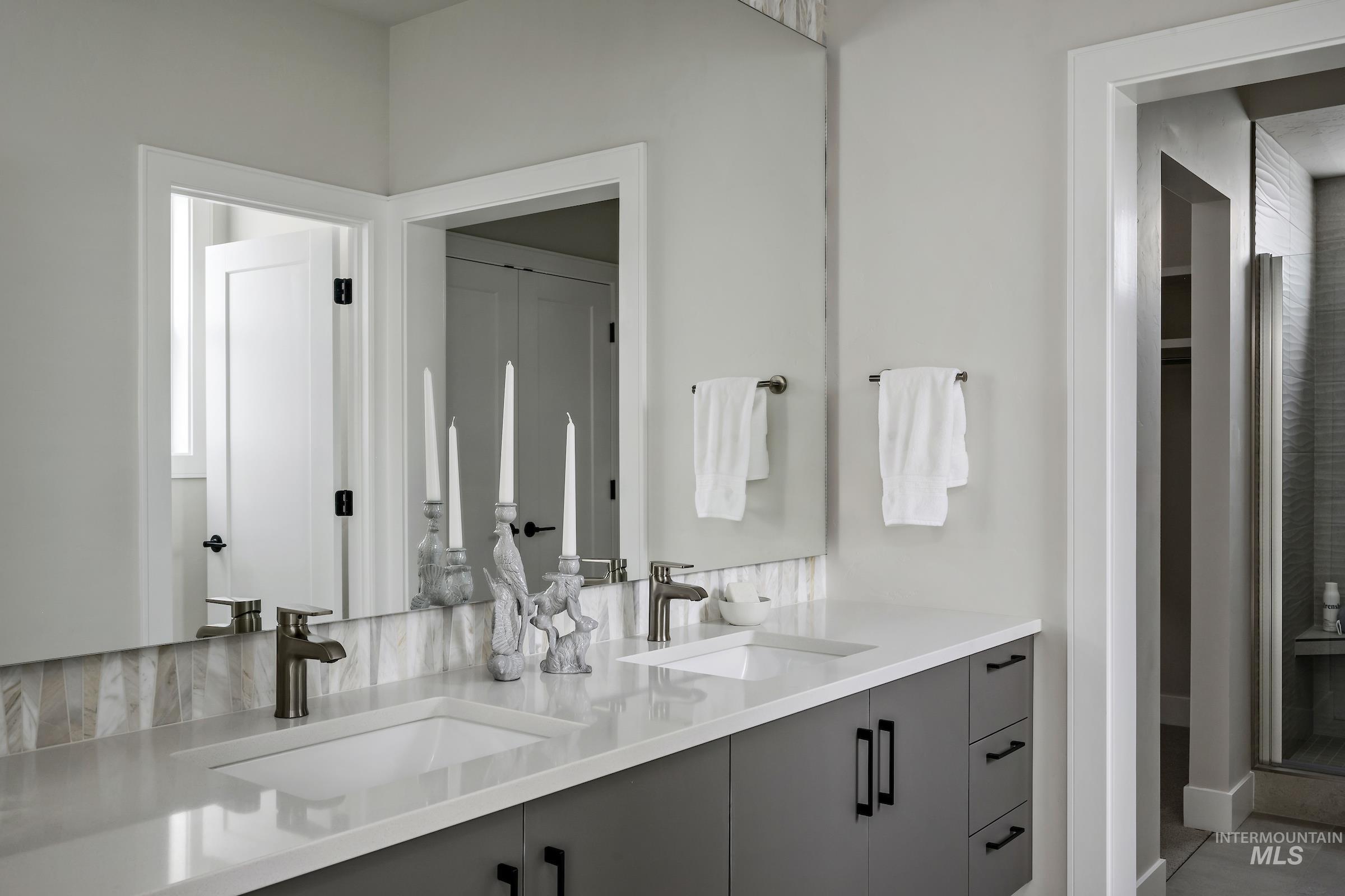 Bathroom featuring double vanity and a shower stall