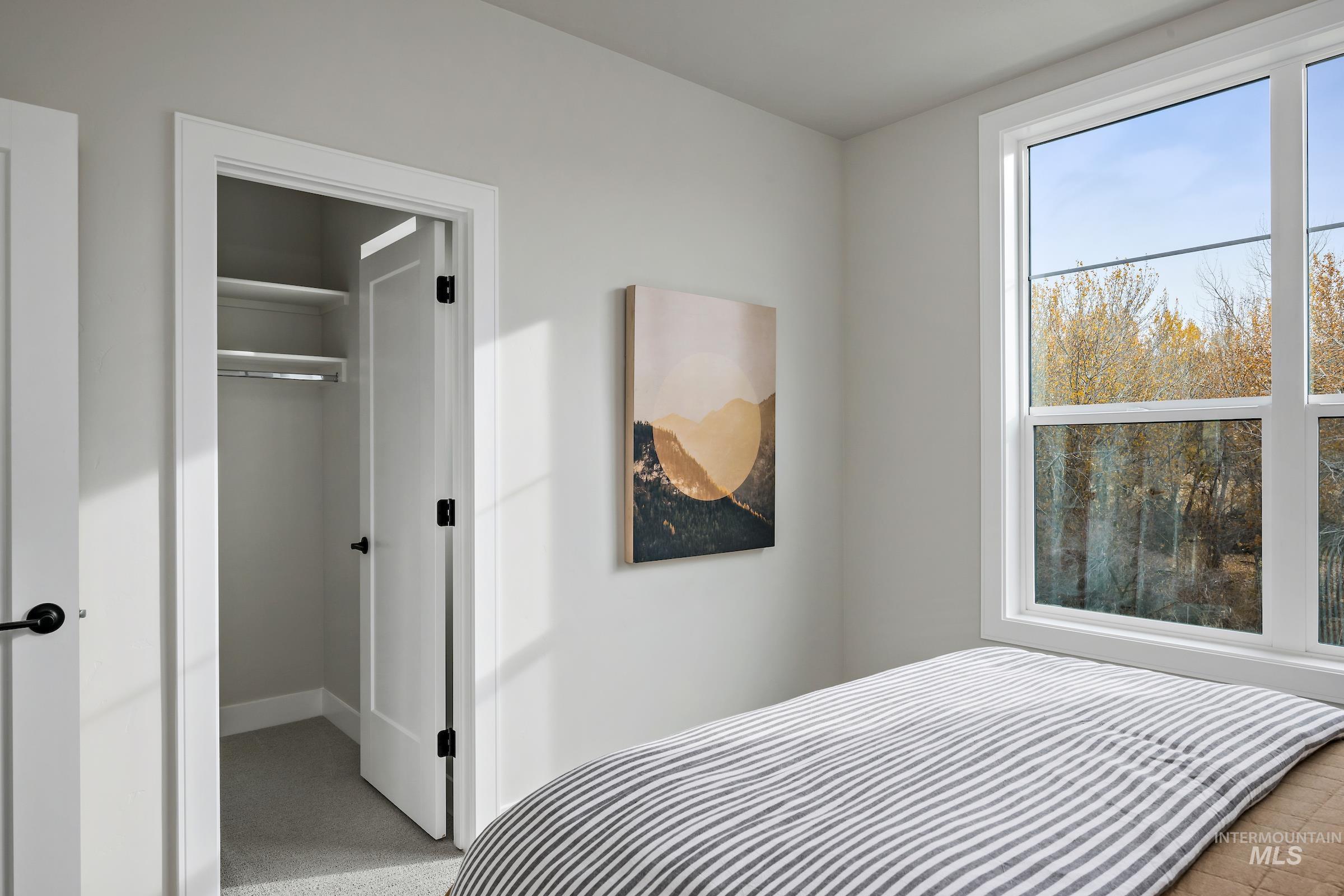 Bedroom featuring light carpet and a spacious closet