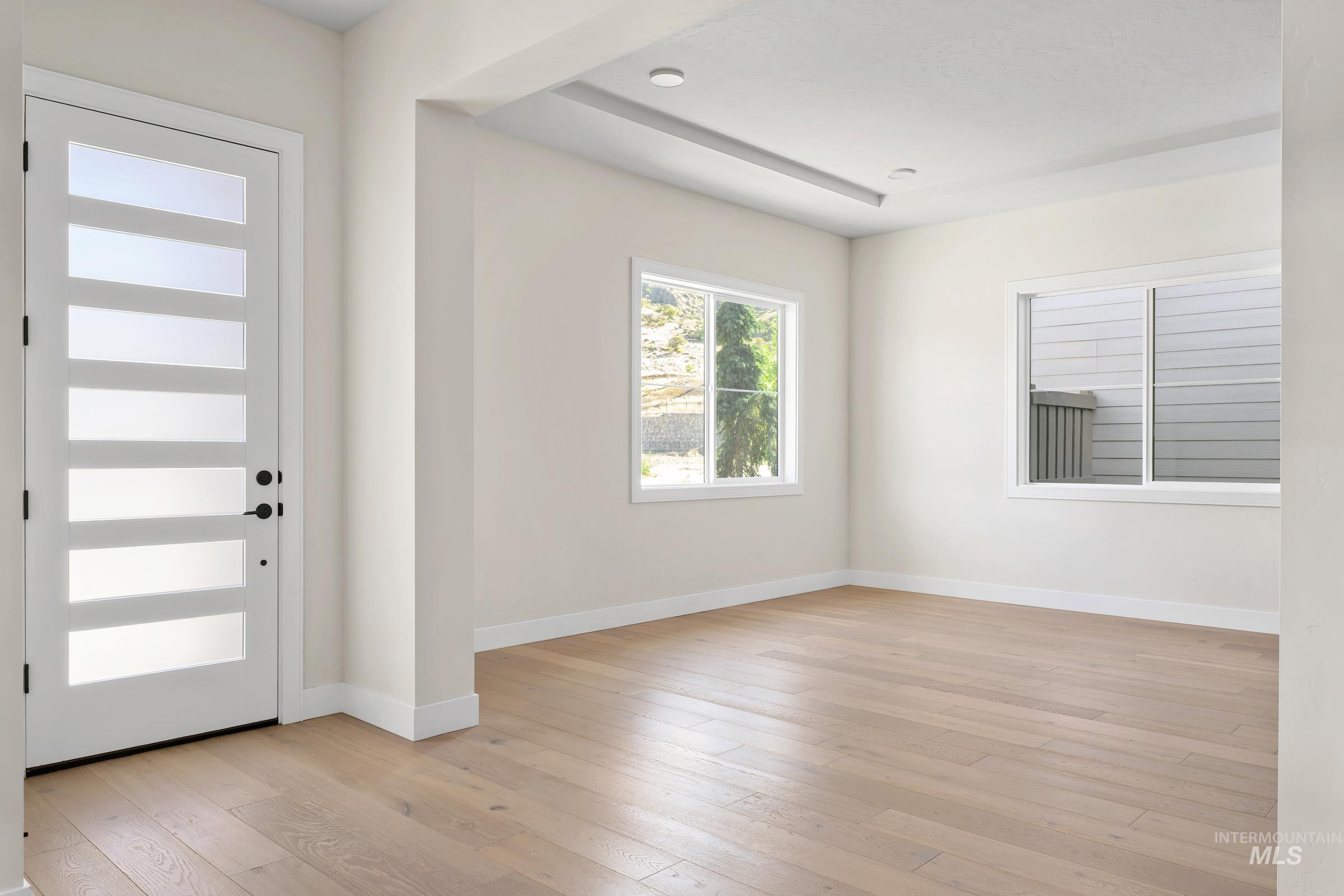 Foyer entrance with light wood-style floors and baseboards