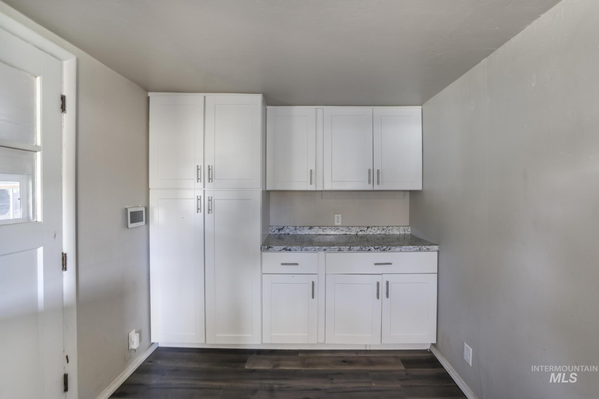 Kitchen featuring white cabinetry and dark wood finished floors