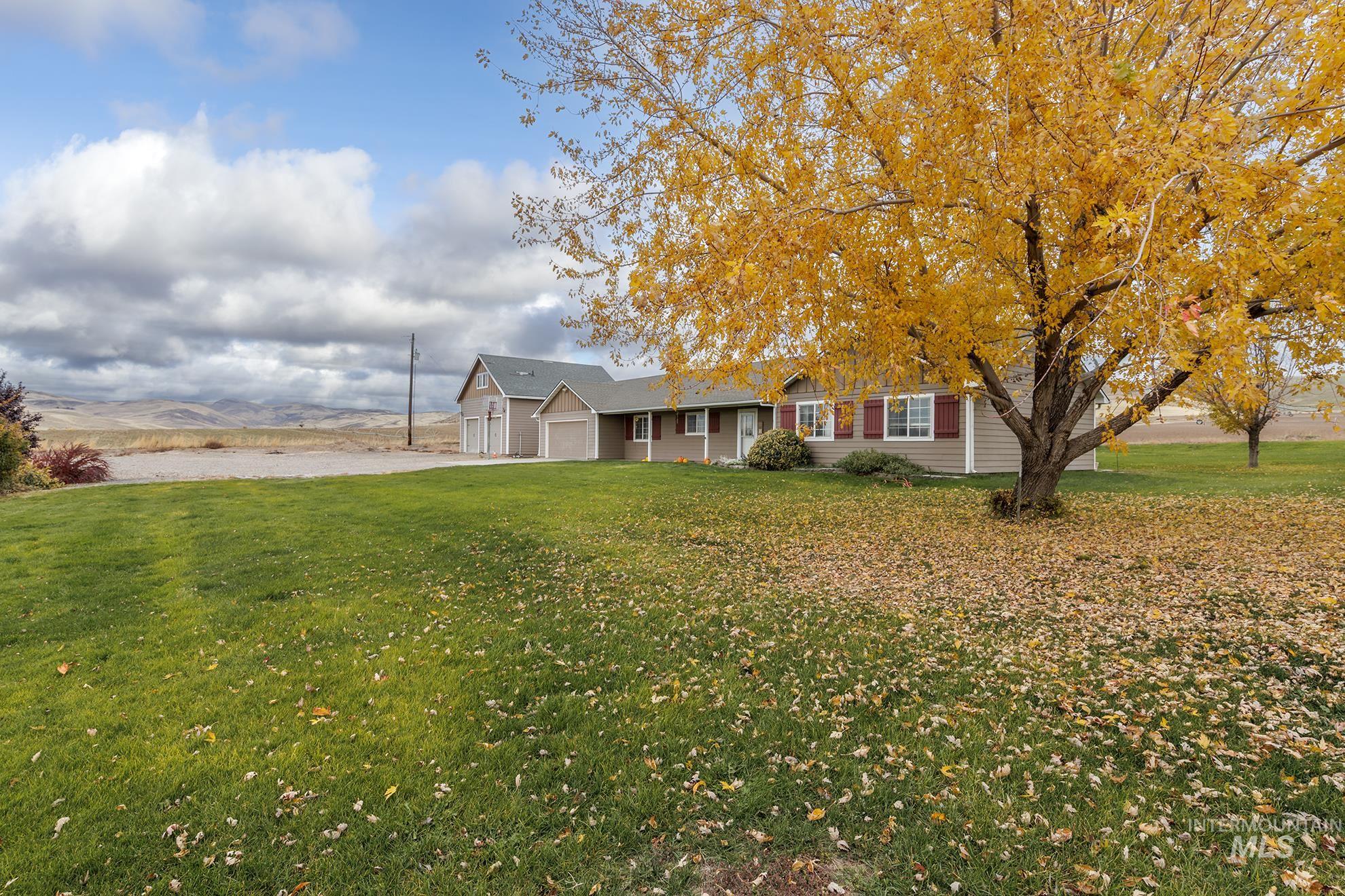 Ranch-style house with a front yard, a garage, driveway, and a mountain view