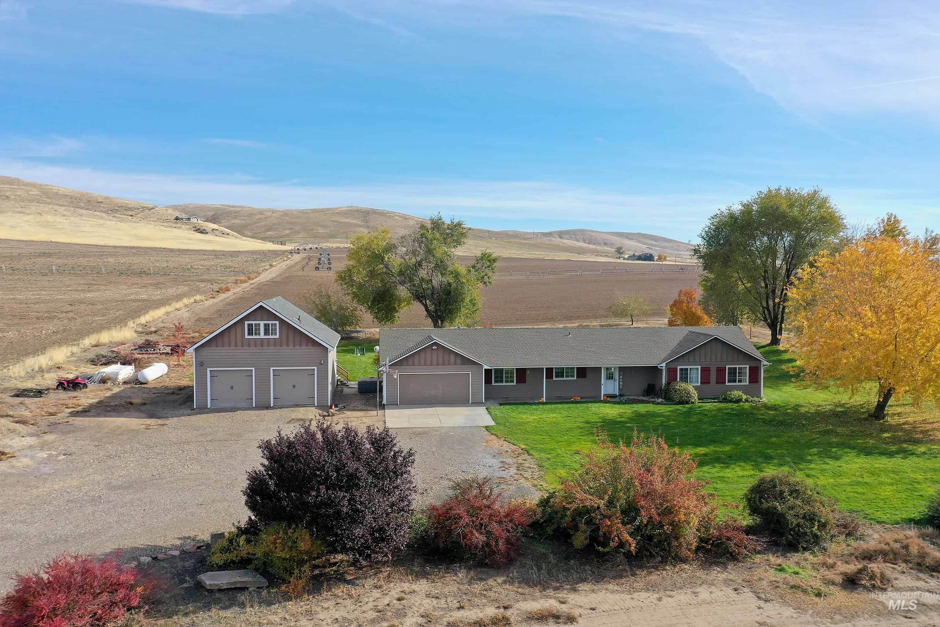 Ranch-style house with driveway, a front lawn, a mountain view, and a rural view