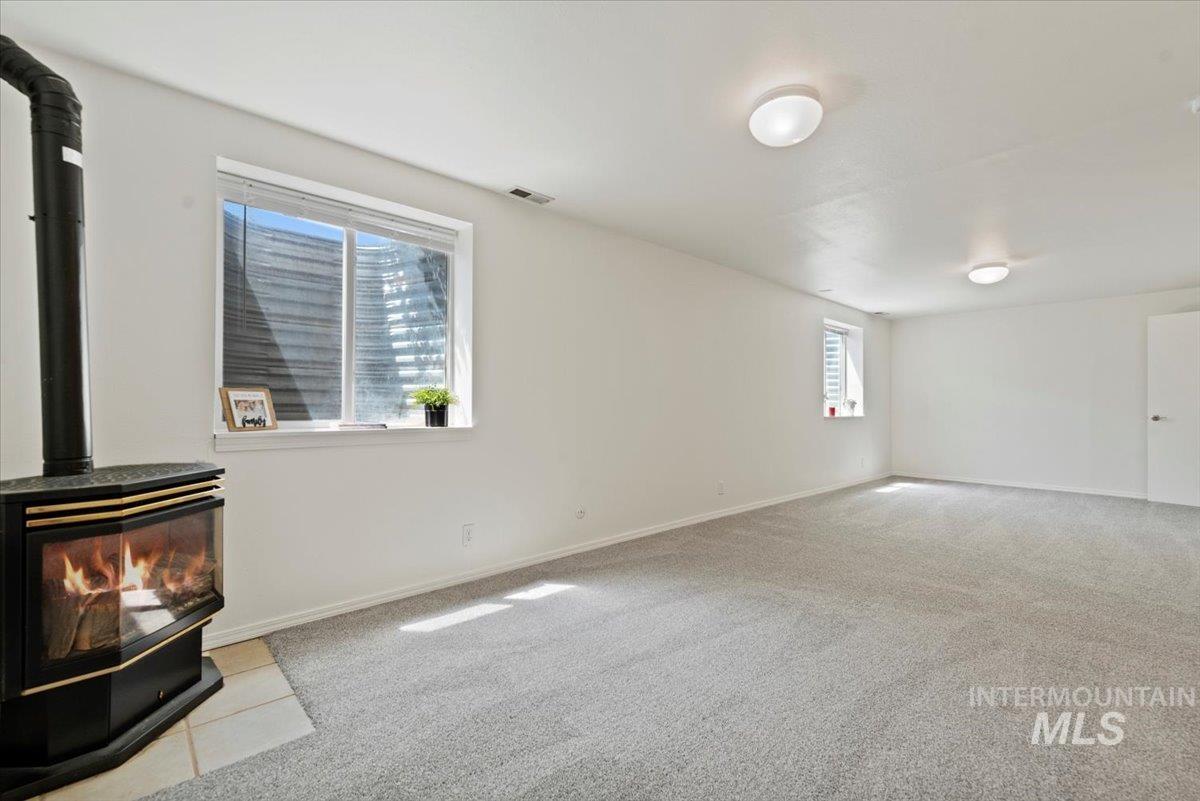 Basement Family room with a wood stove and carpet