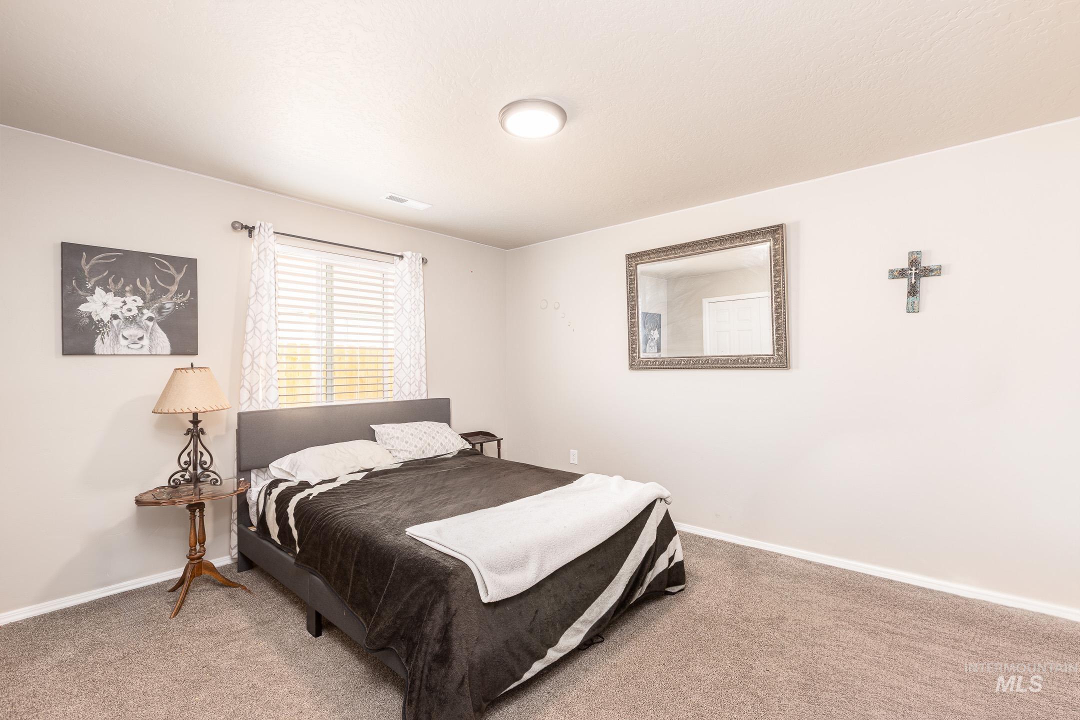 Bedroom featuring carpet floors and baseboards