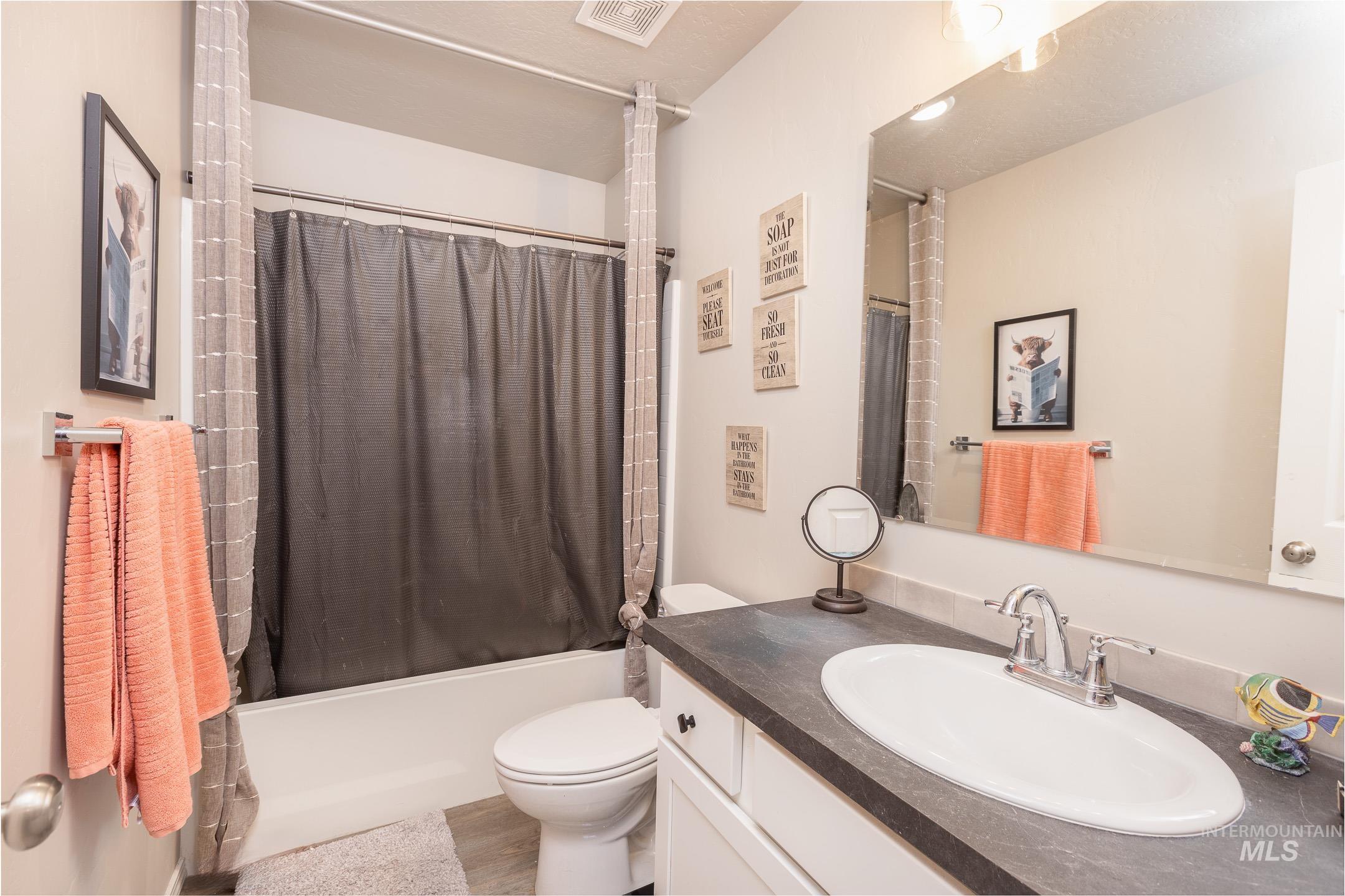 Bathroom with shower / bath combination with curtain and vanity