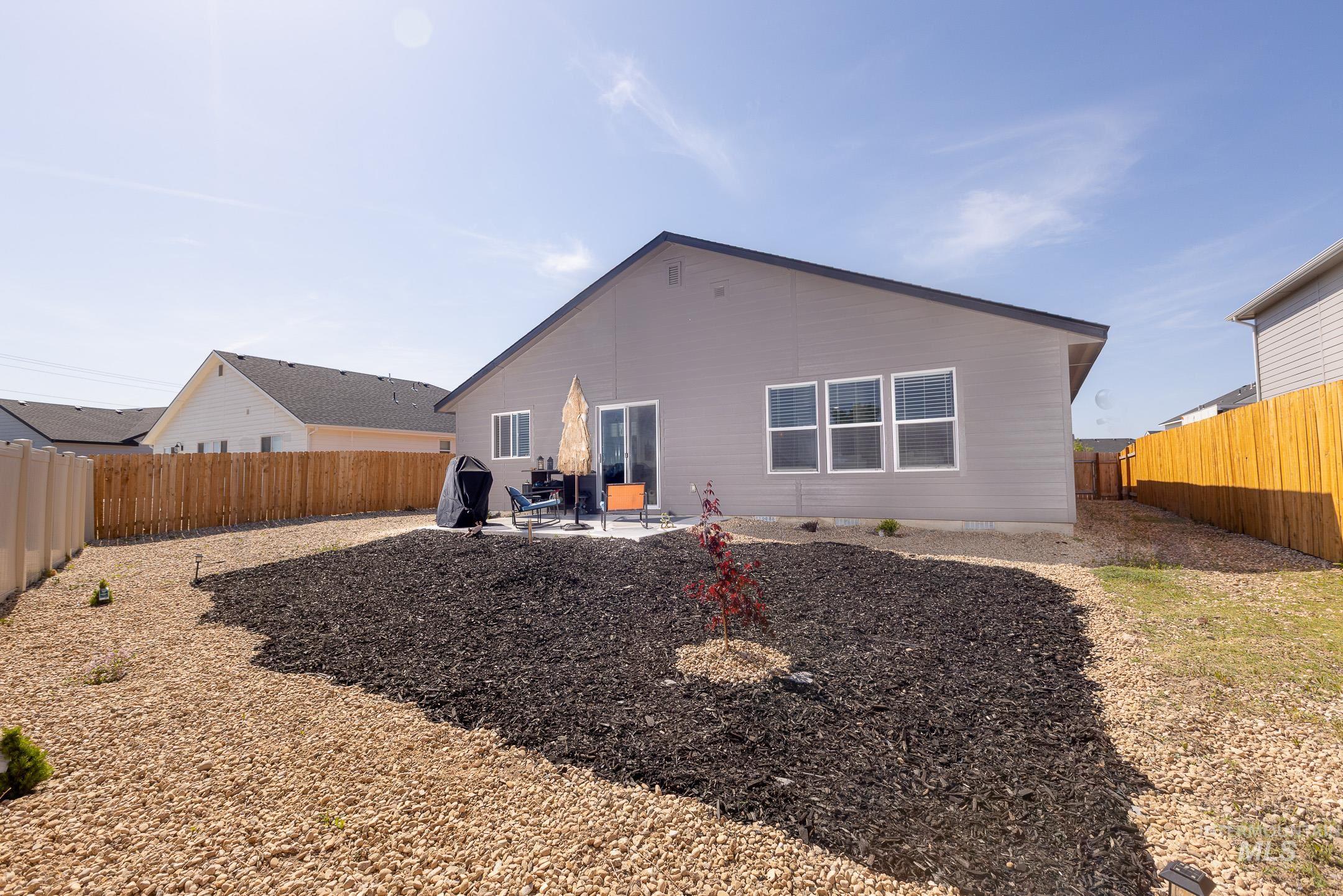 Rear view of house featuring a patio and a fenced backyard