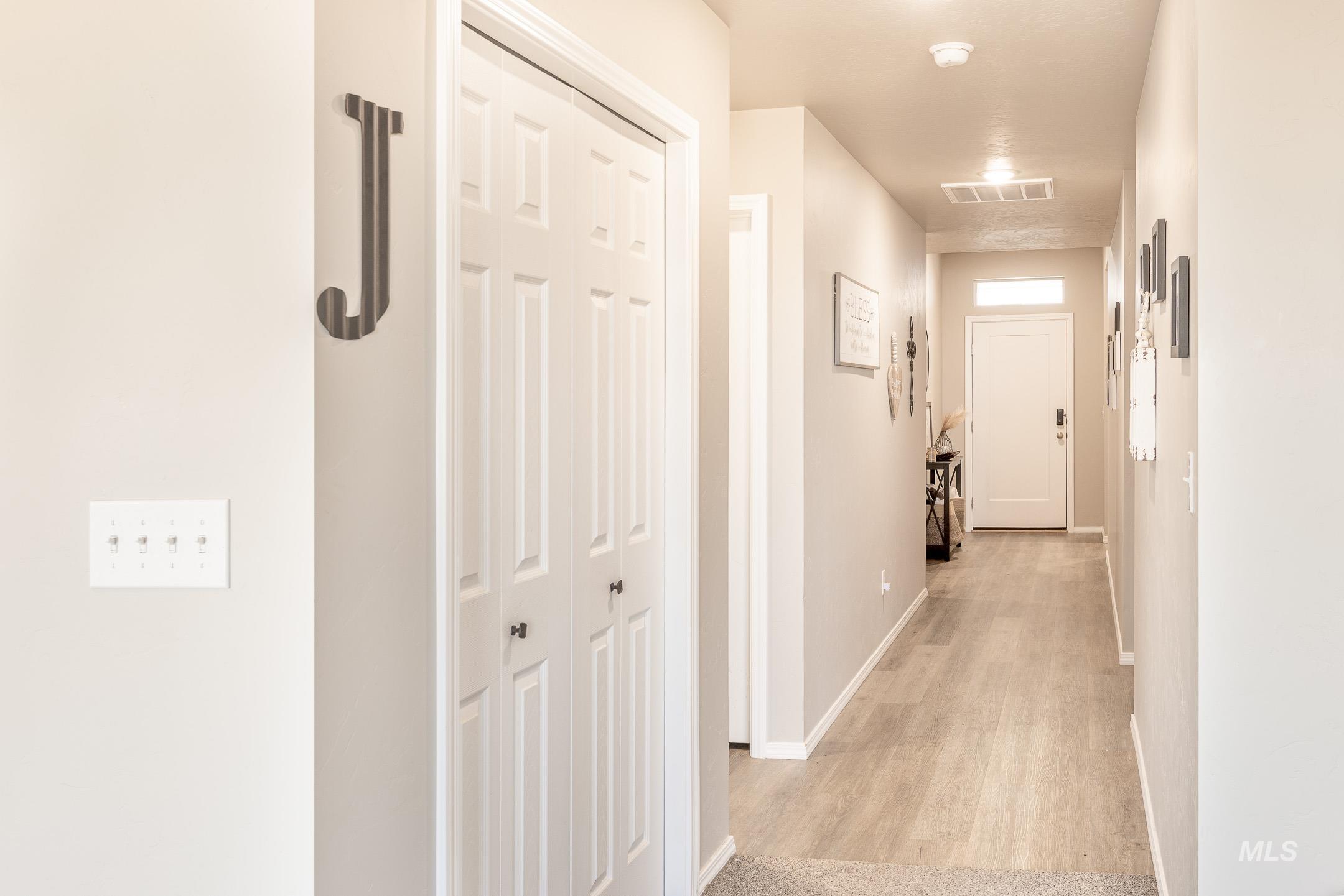 Hall with light wood finished floors and baseboards
