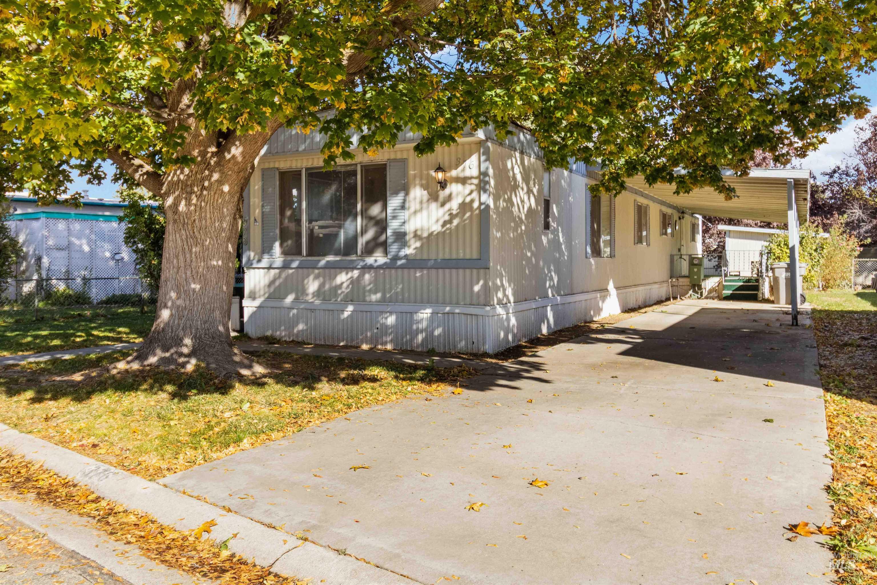 View of side of home with driveway and a carport