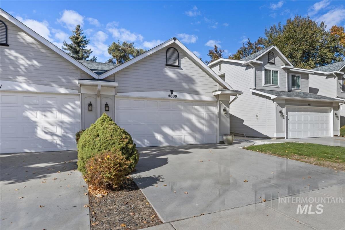 View of side of property featuring driveway and a shingled roof