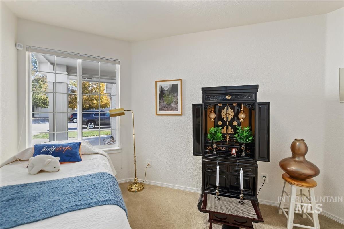 Bedroom featuring carpet and a textured wall
