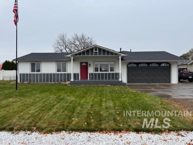 Single story home with a front lawn, driveway, a garage, and a porch
