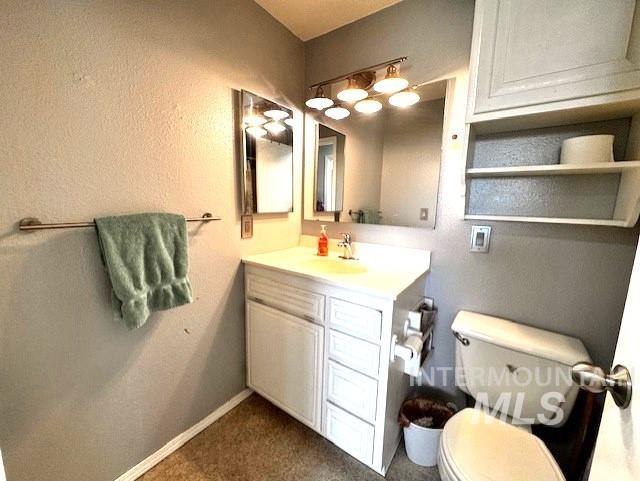 Half bathroom with vanity and toilet