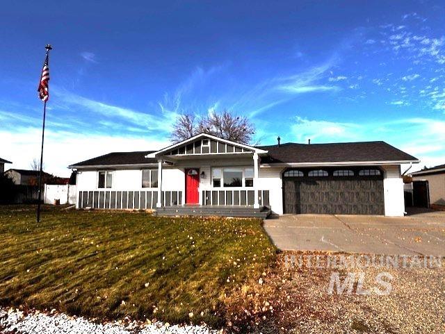 Ranch-style house with covered porch, a front lawn, an attached garage, and concrete driveway