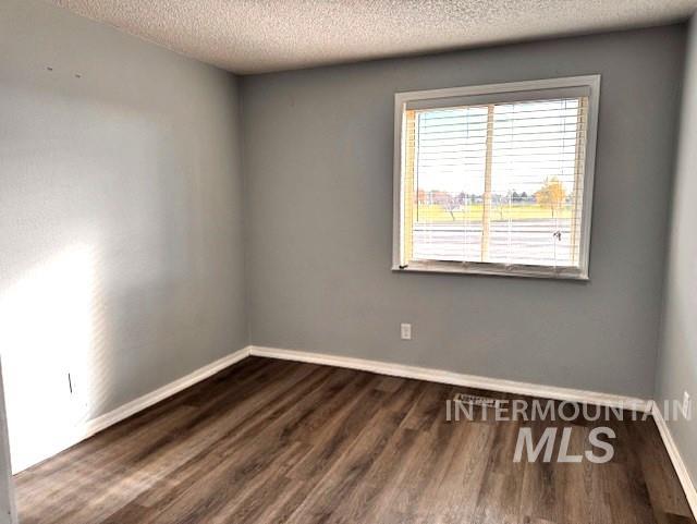 Spare room with dark wood finished floors and a textured ceiling