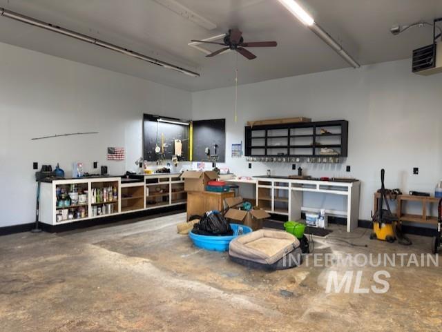 Garage featuring a workshop area, a ceiling fan, and a heating unit