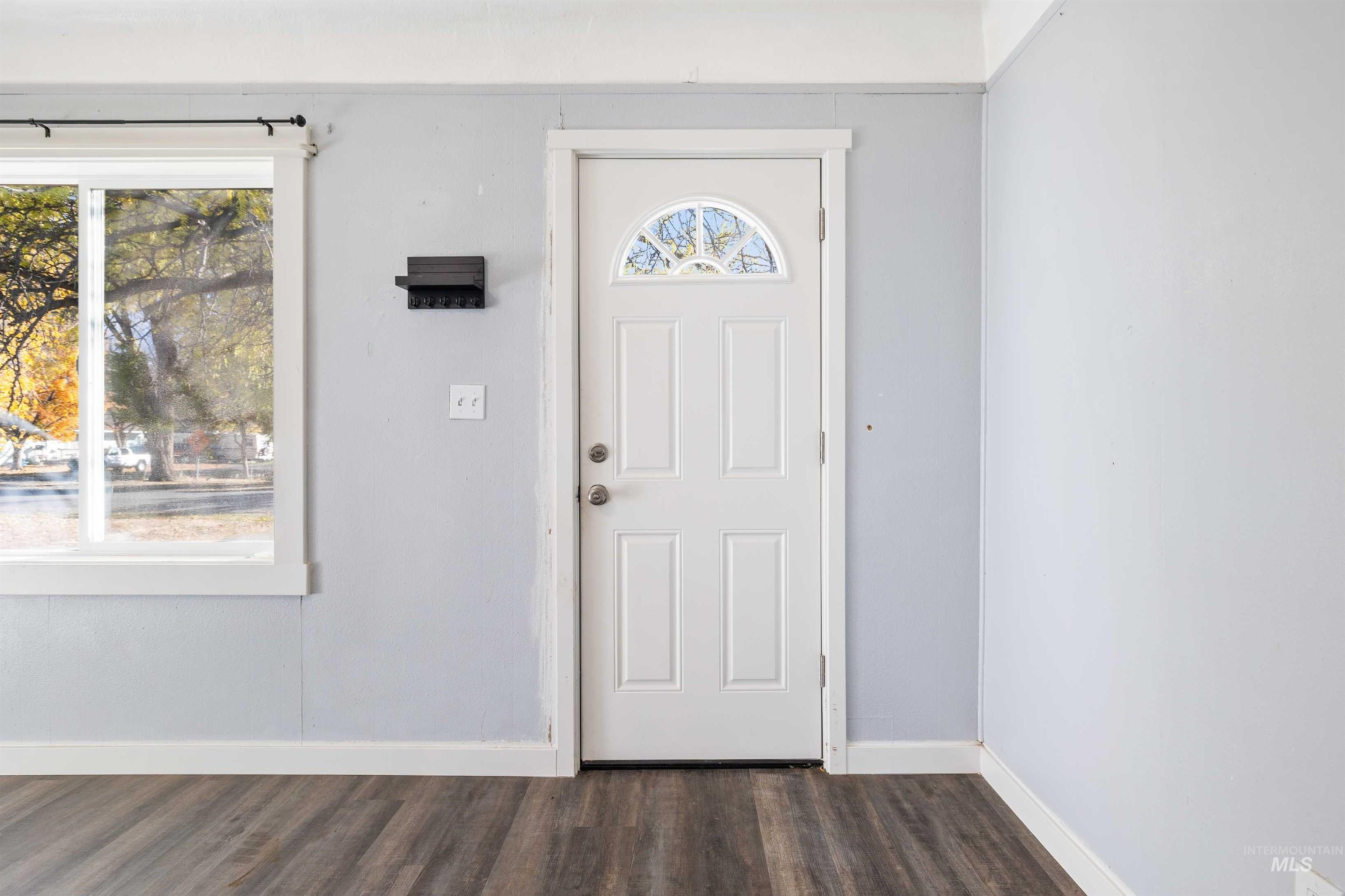 Foyer with baseboards and dark wood-style flooring