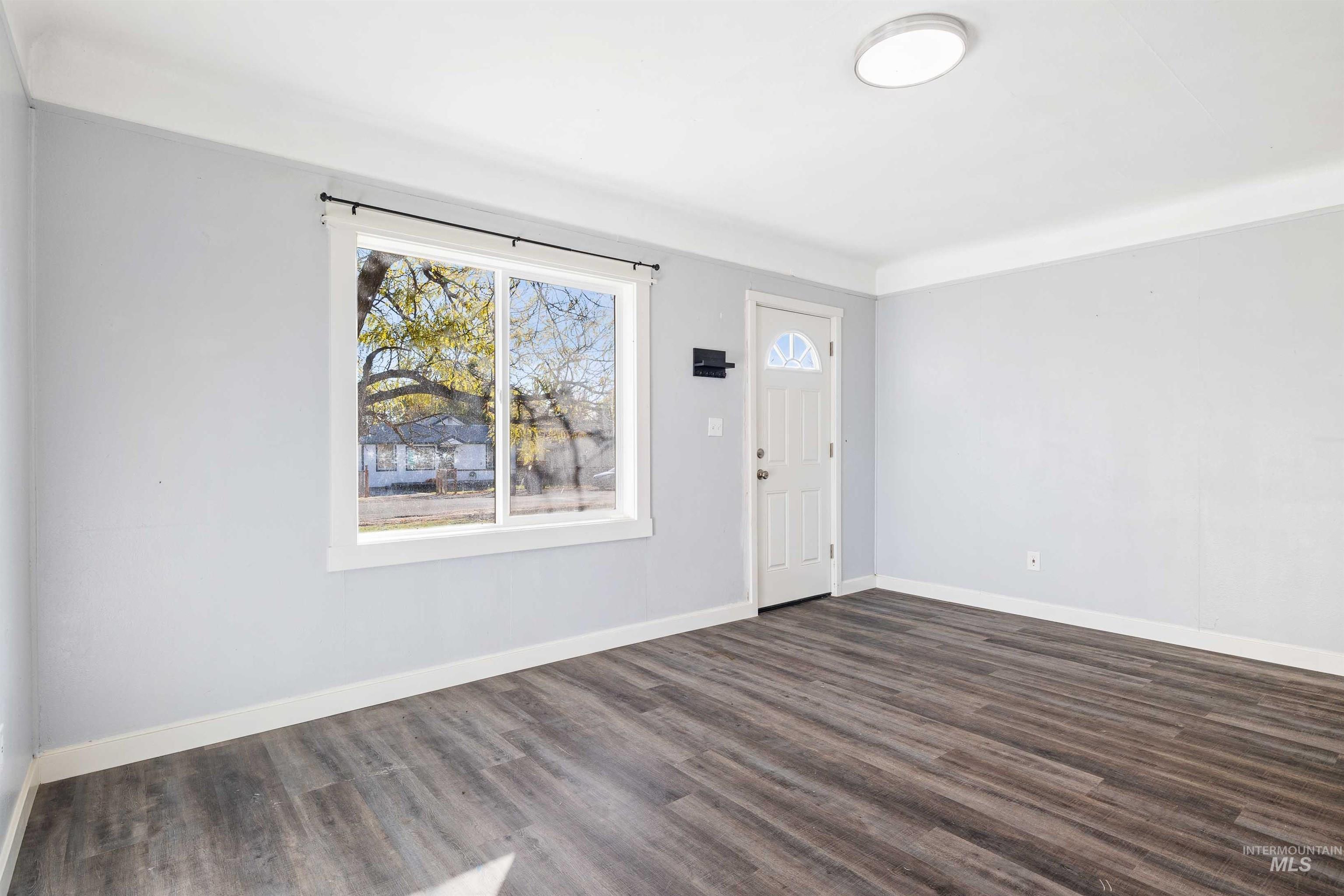 Entryway with baseboards and dark wood-style floors
