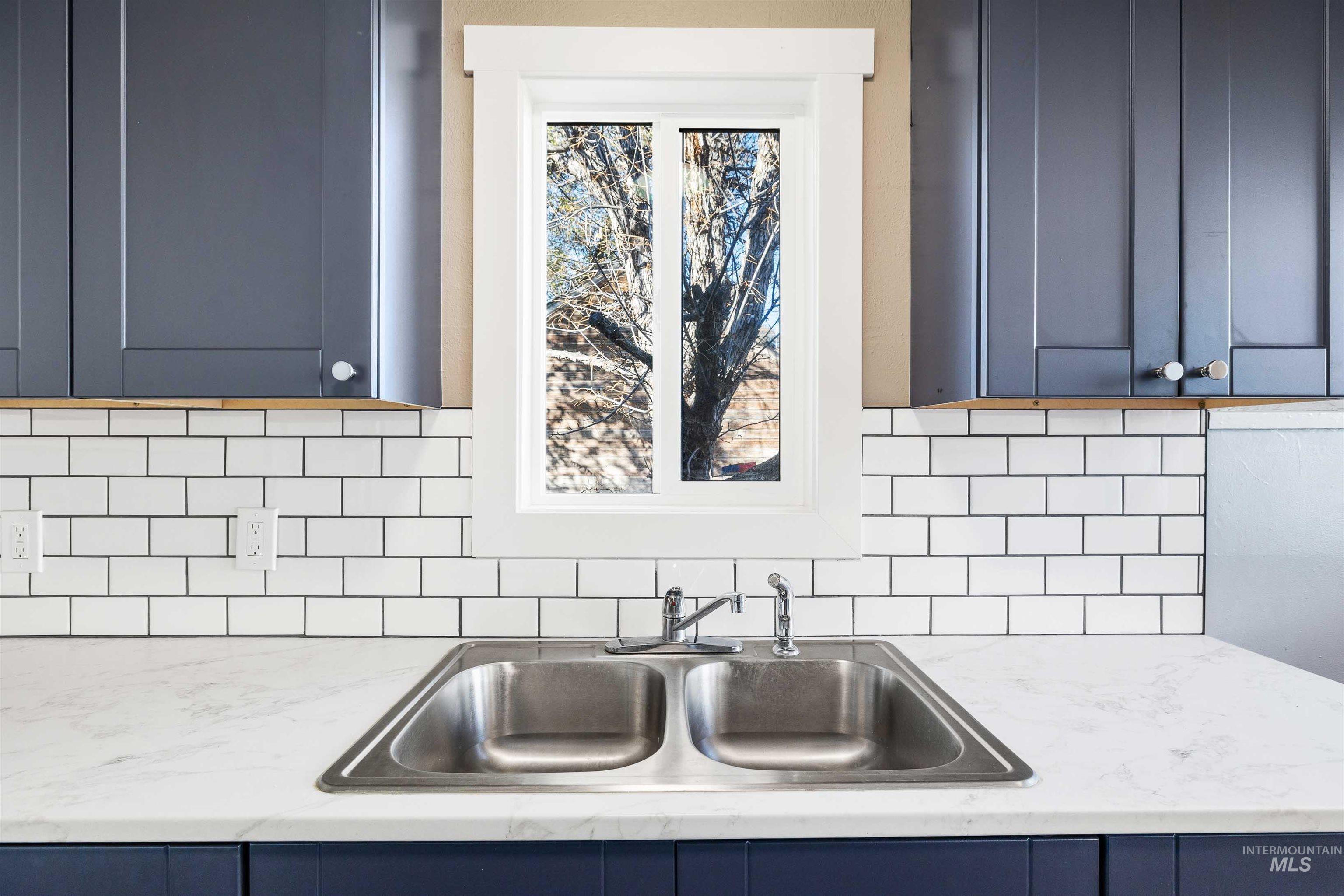 Kitchen with blue cabinets and decorative backsplash