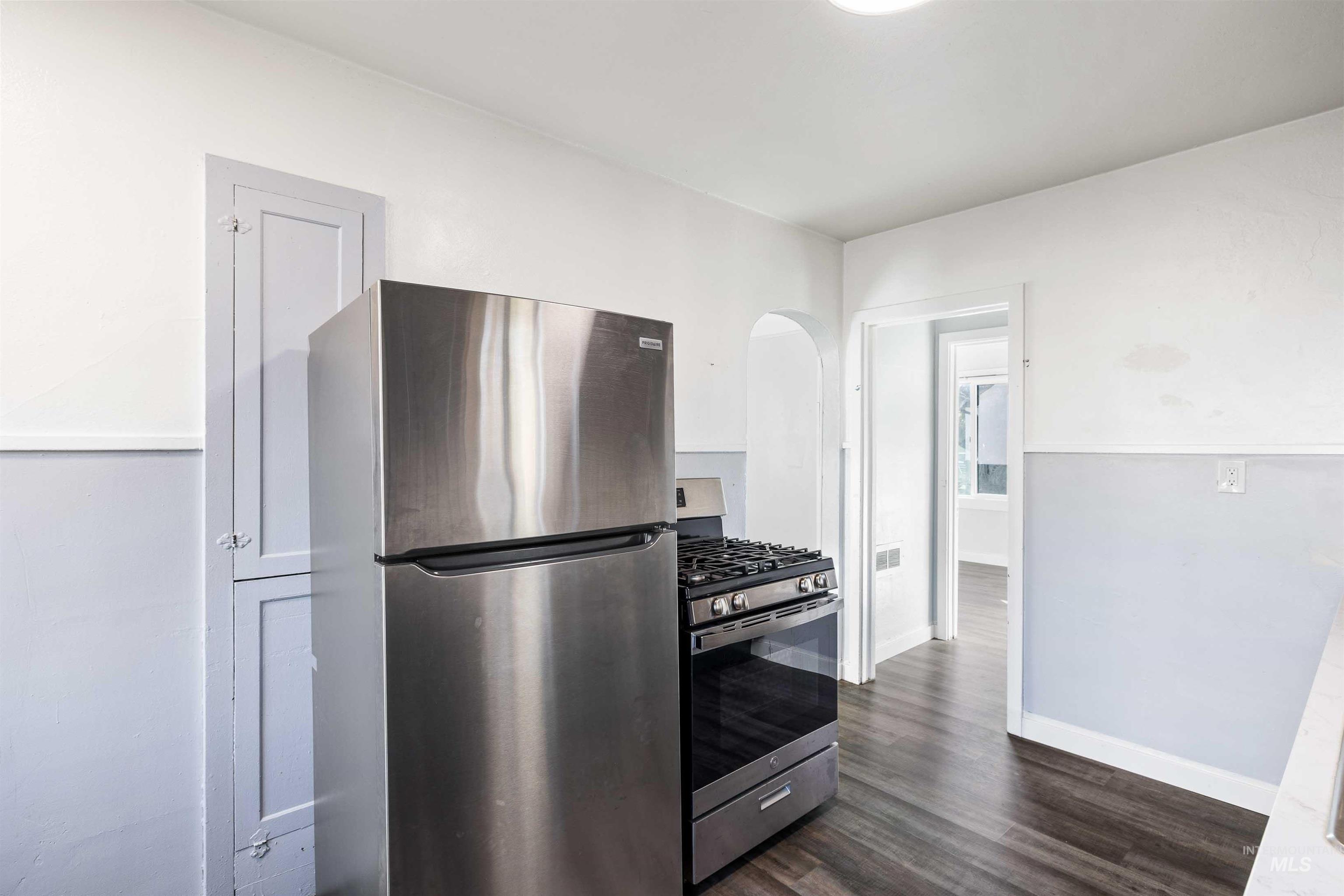 Kitchen featuring appliances with stainless steel finishes and dark wood-style flooring
