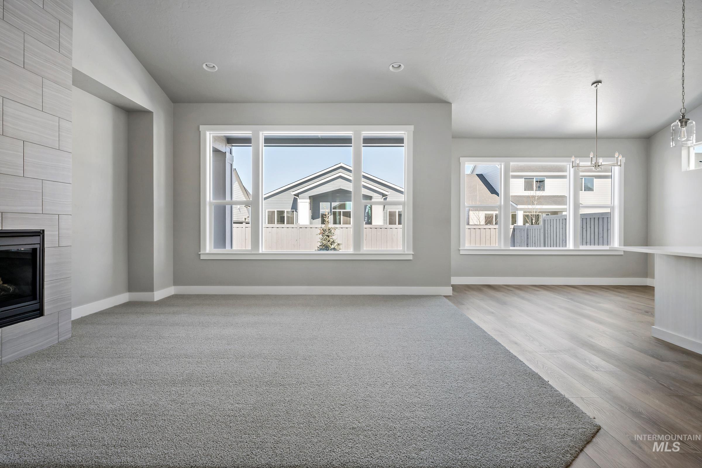 Unfurnished living room with plenty of natural light, a fireplace, and light wood-style floors