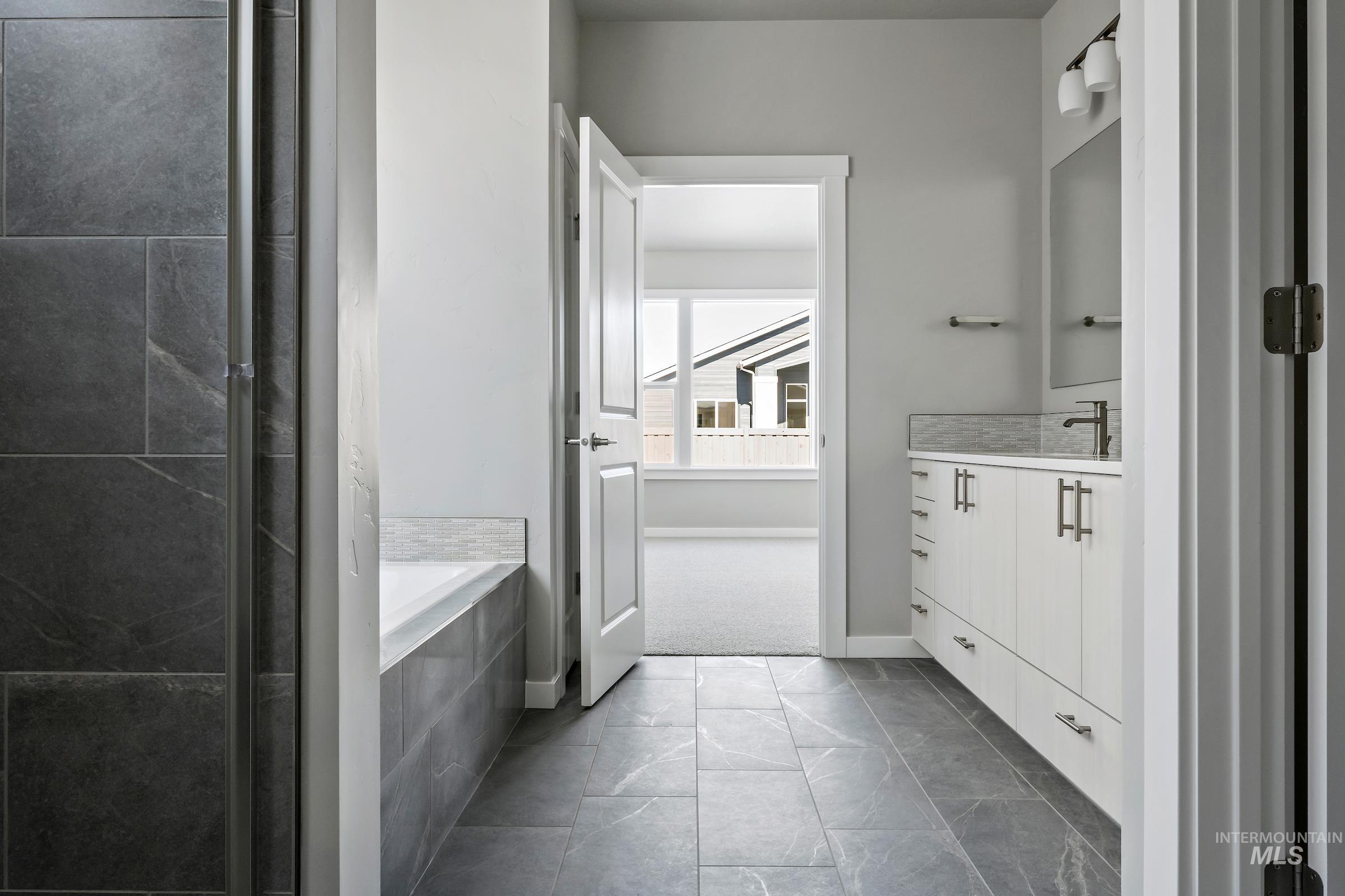 Full bathroom featuring vanity and a relaxing tiled tub