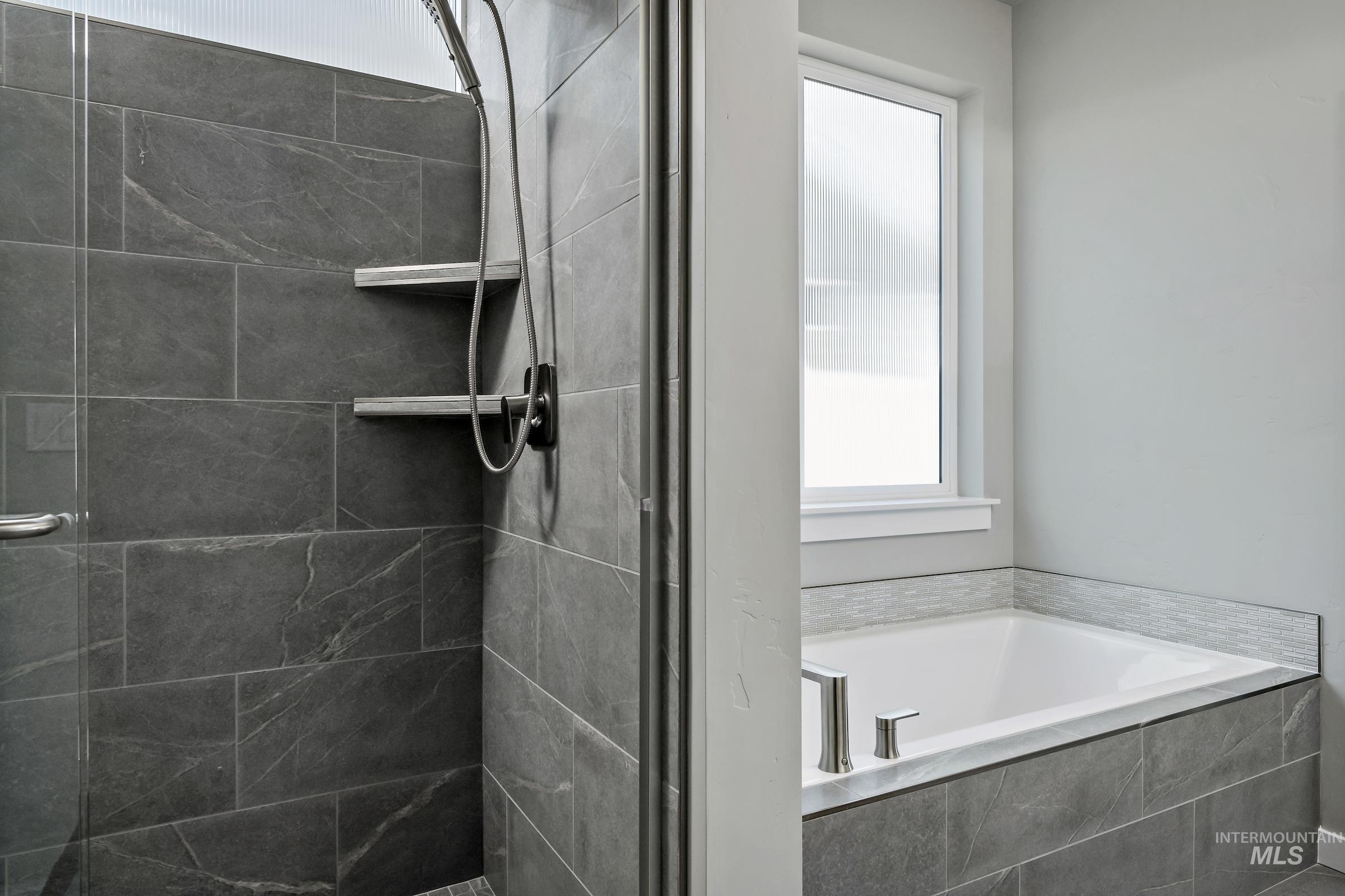 Full bath featuring plenty of natural light, a stall shower, and a bath