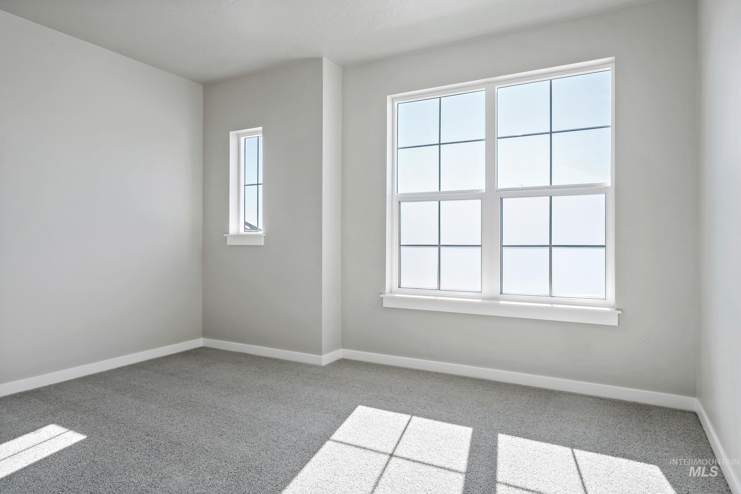 Empty room with light carpet and baseboards