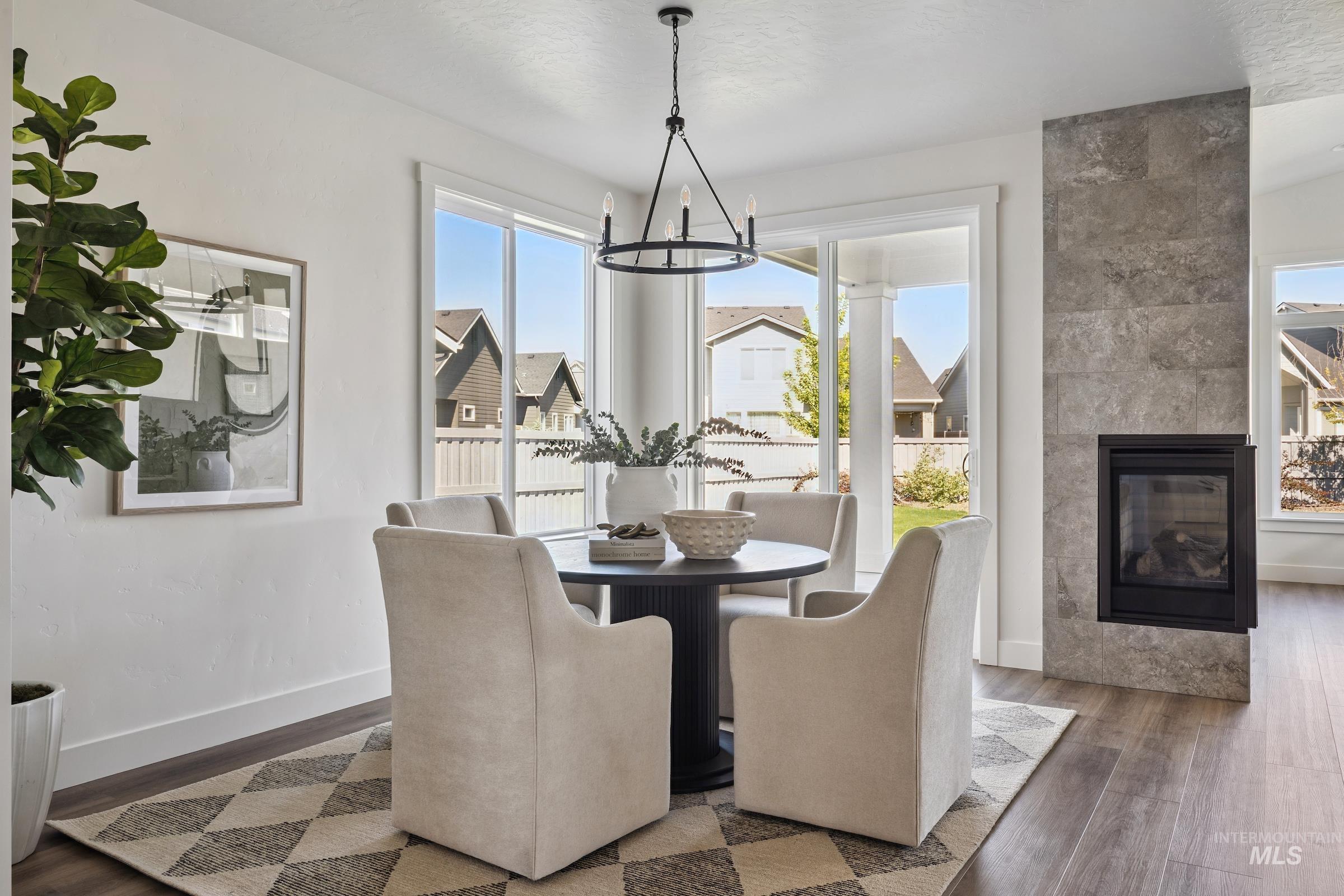 Dining area featuring a fireplace, wood finished floors, and a chandelier
