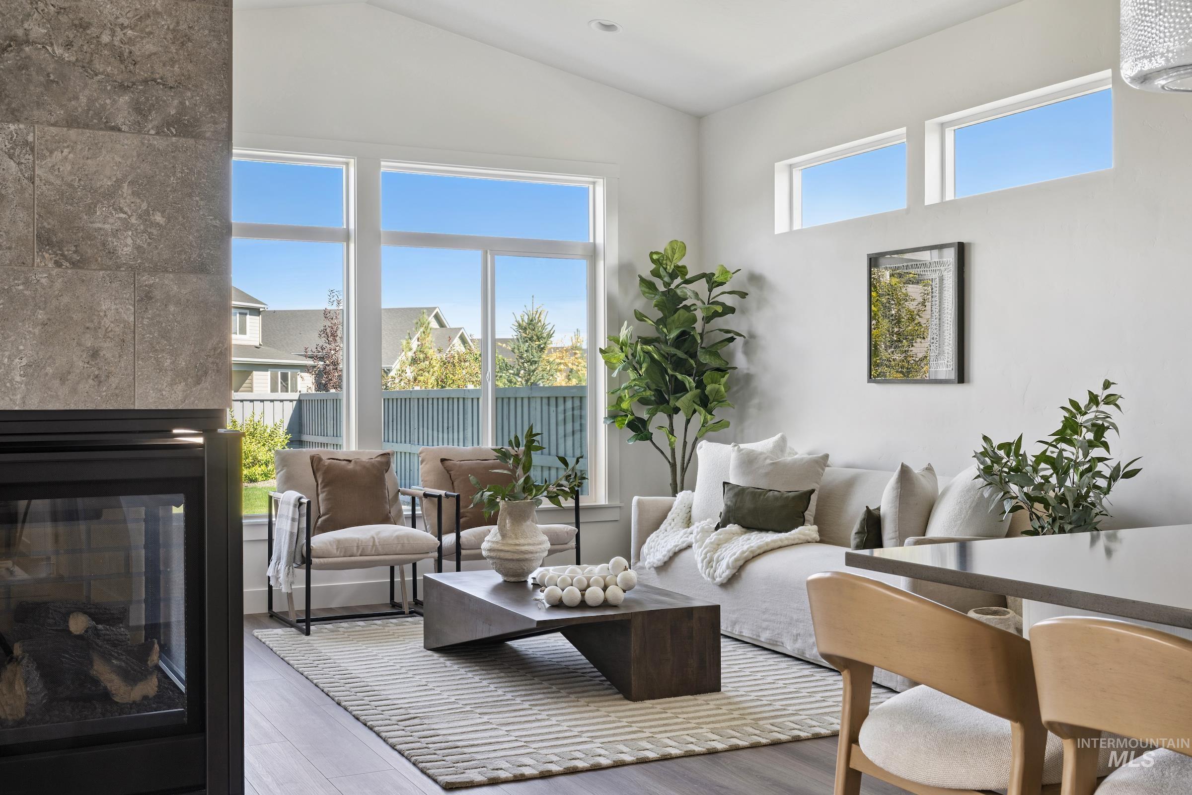 Living room featuring wood finished floors, lofted ceiling, and a tiled fireplace