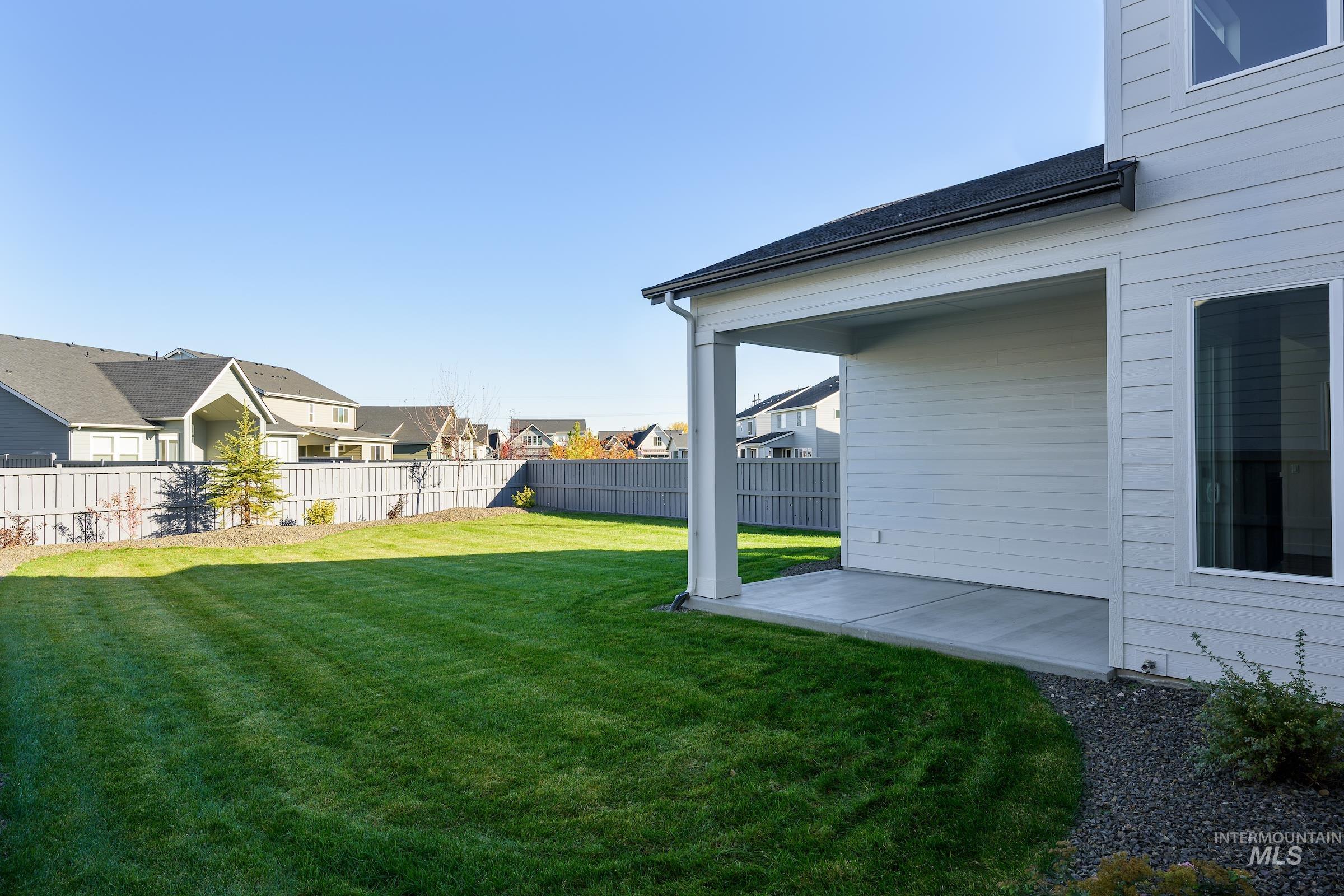 Fenced backyard with a patio area and a residential view