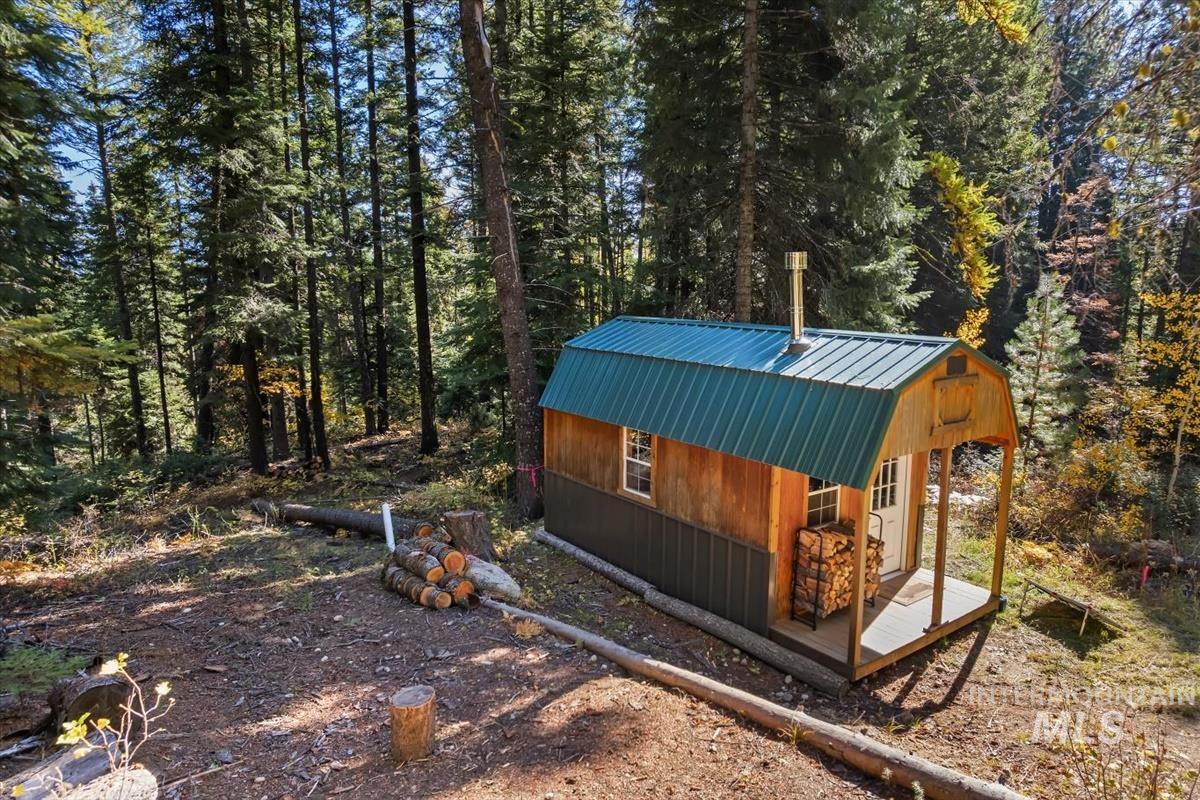 View of yard featuring an outdoor structure and a view of trees