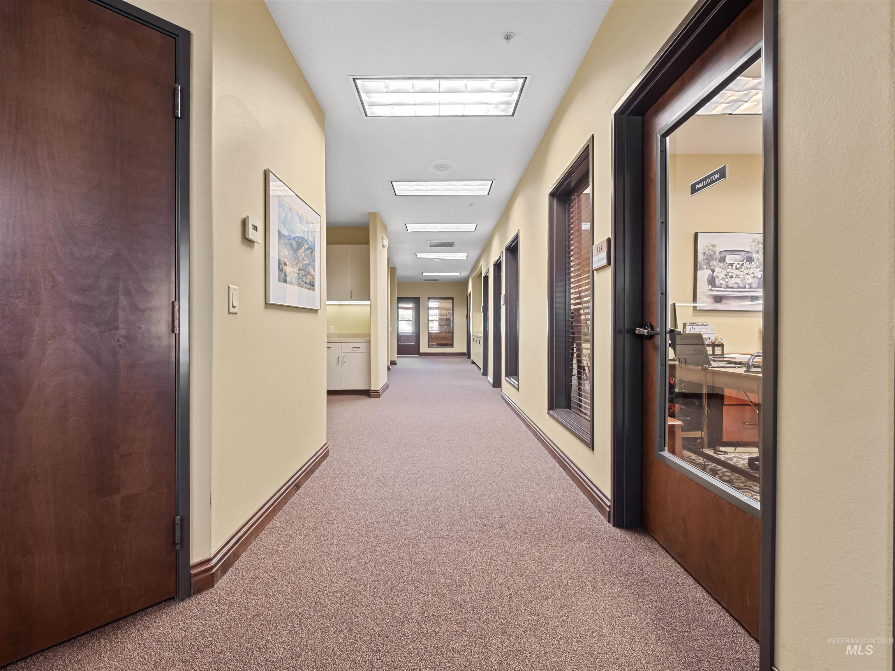 Corridor with light carpet and baseboards