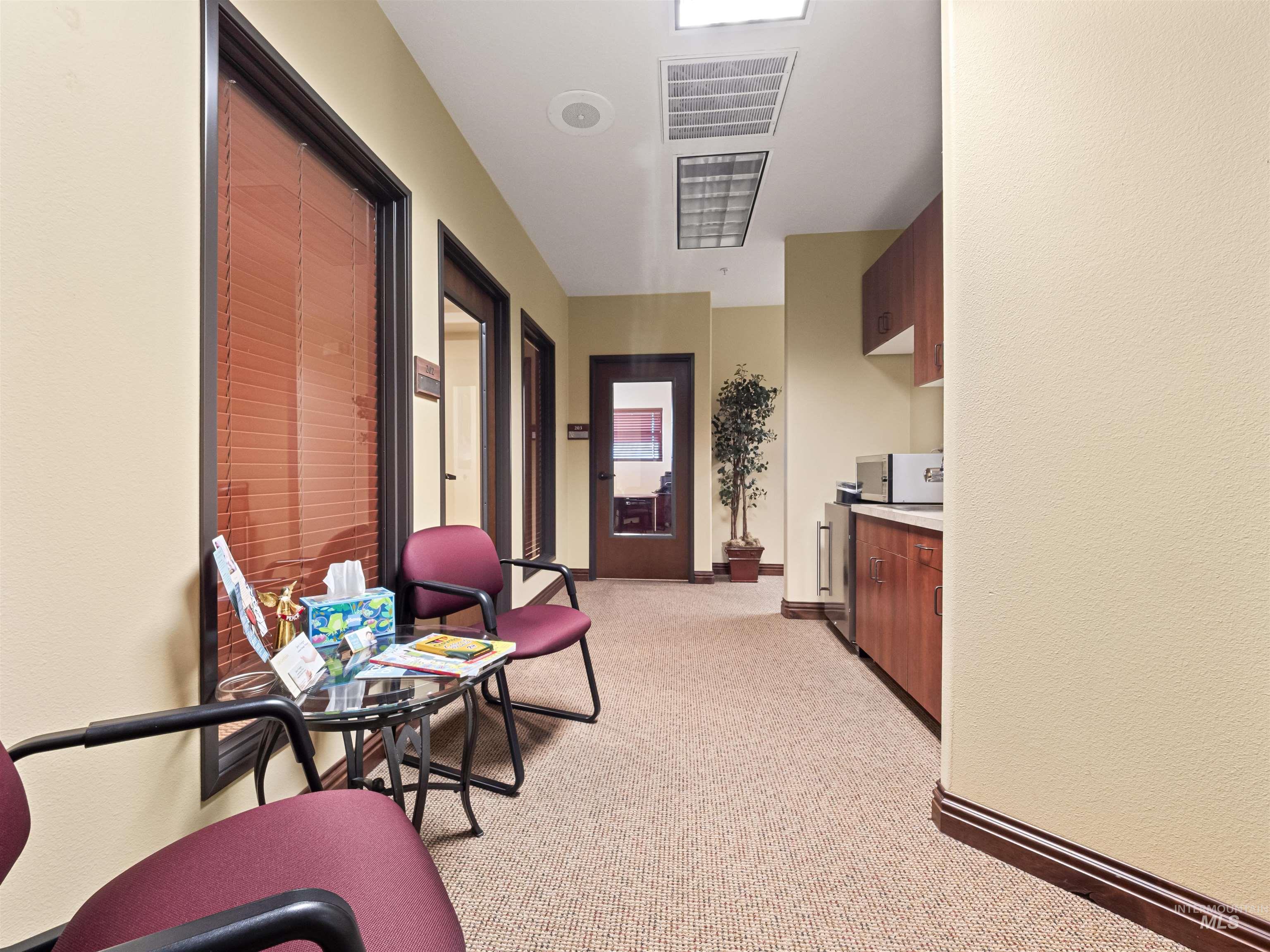 Corridor featuring light colored carpet and wine cooler