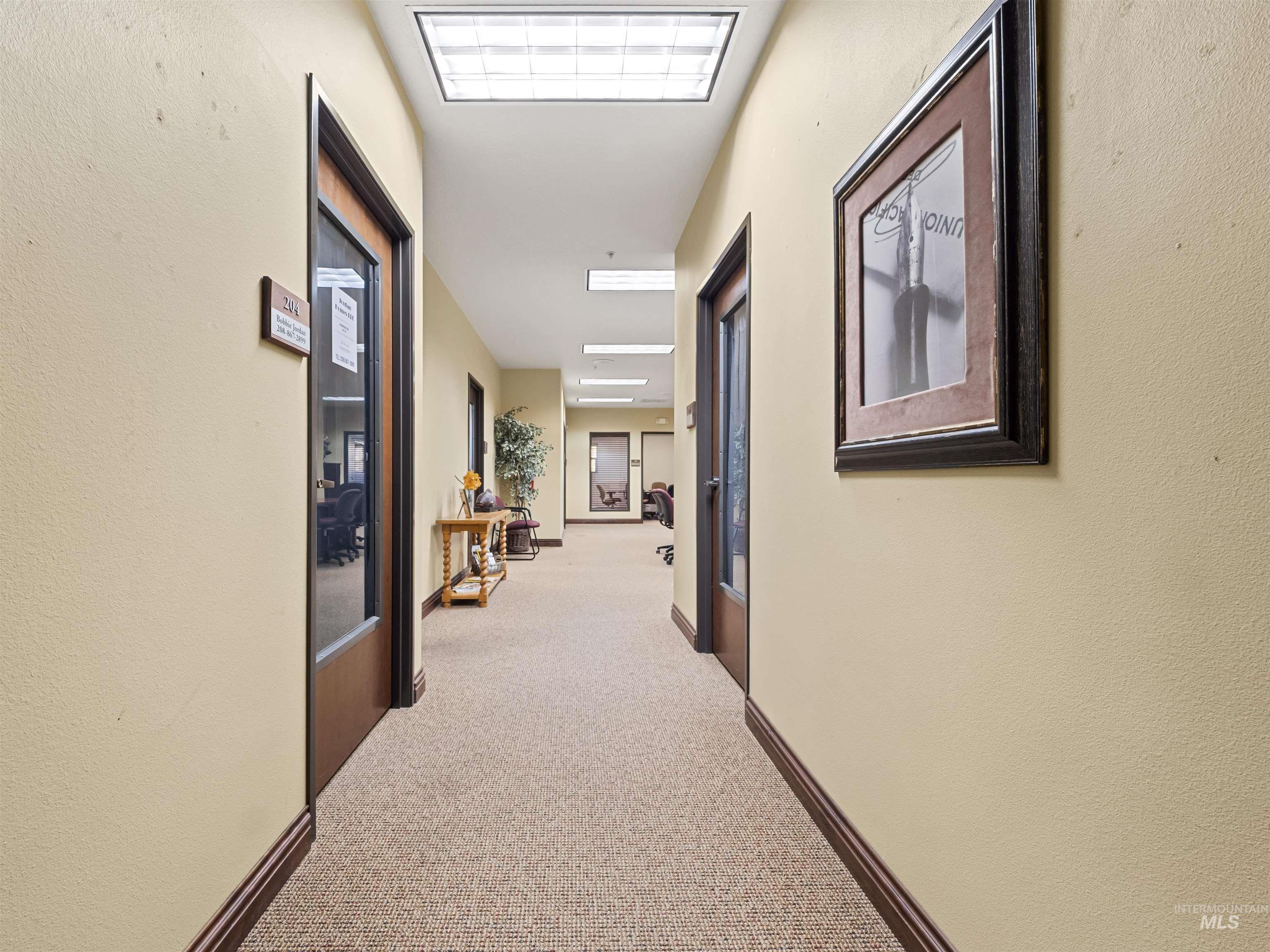 Hall with light colored carpet and a textured wall