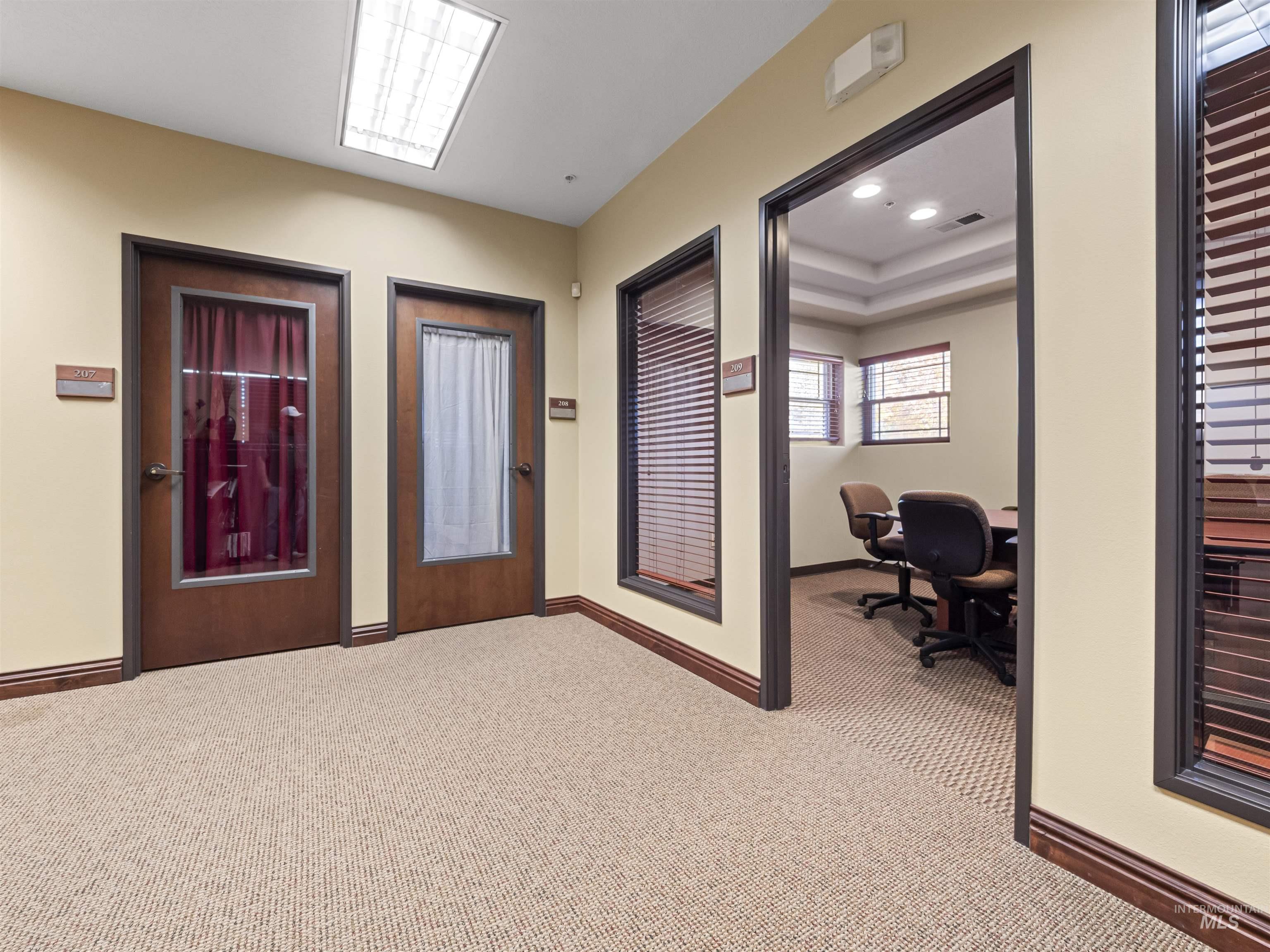 Hallway featuring carpet flooring, recessed lighting, a desk, and a tray ceiling