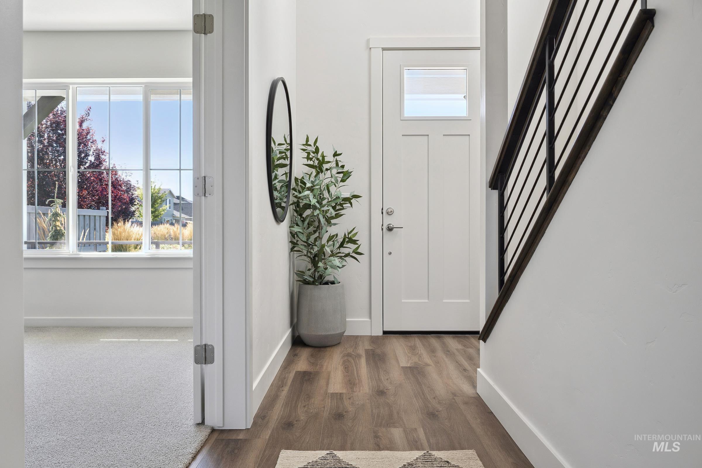 Foyer with wood finished floors and stairway