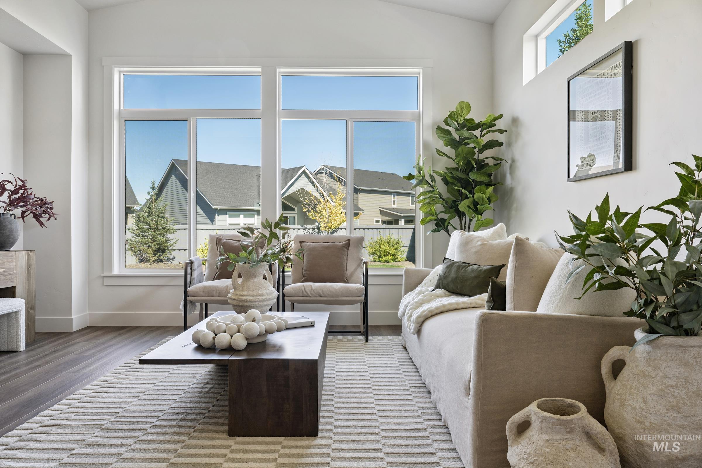 Sitting room with light wood-style flooring and vaulted ceiling