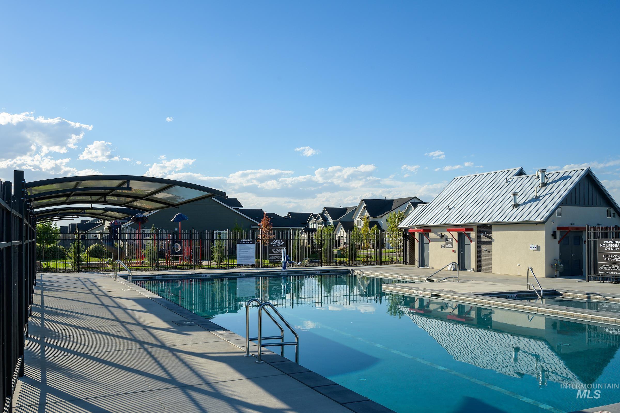Community pool featuring a patio area and a residential view