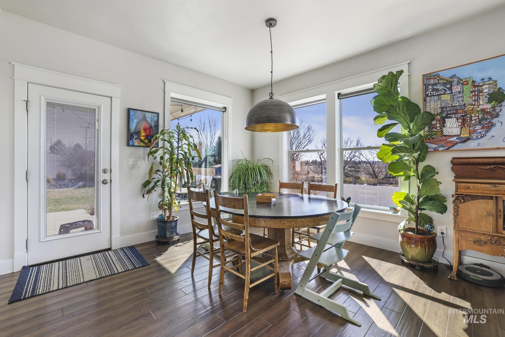 Dining room with dark wood-style flooring and baseboards