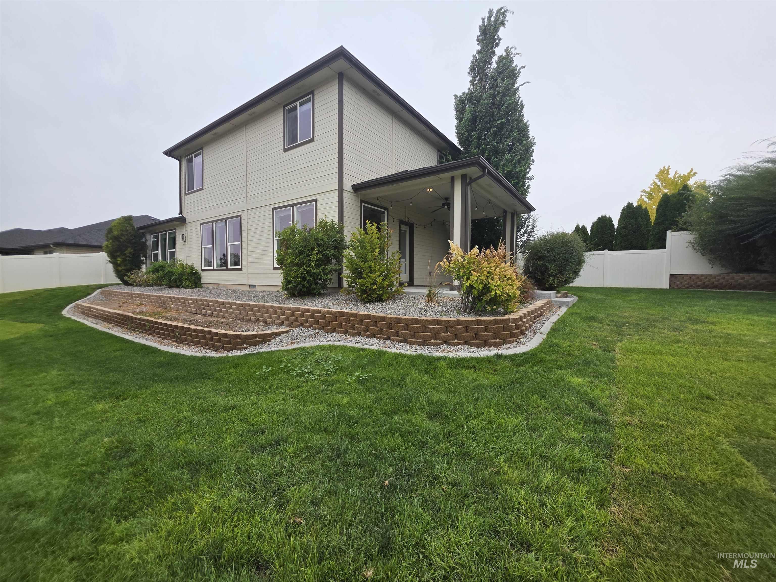 Rear view of house featuring a ceiling fan and a patio