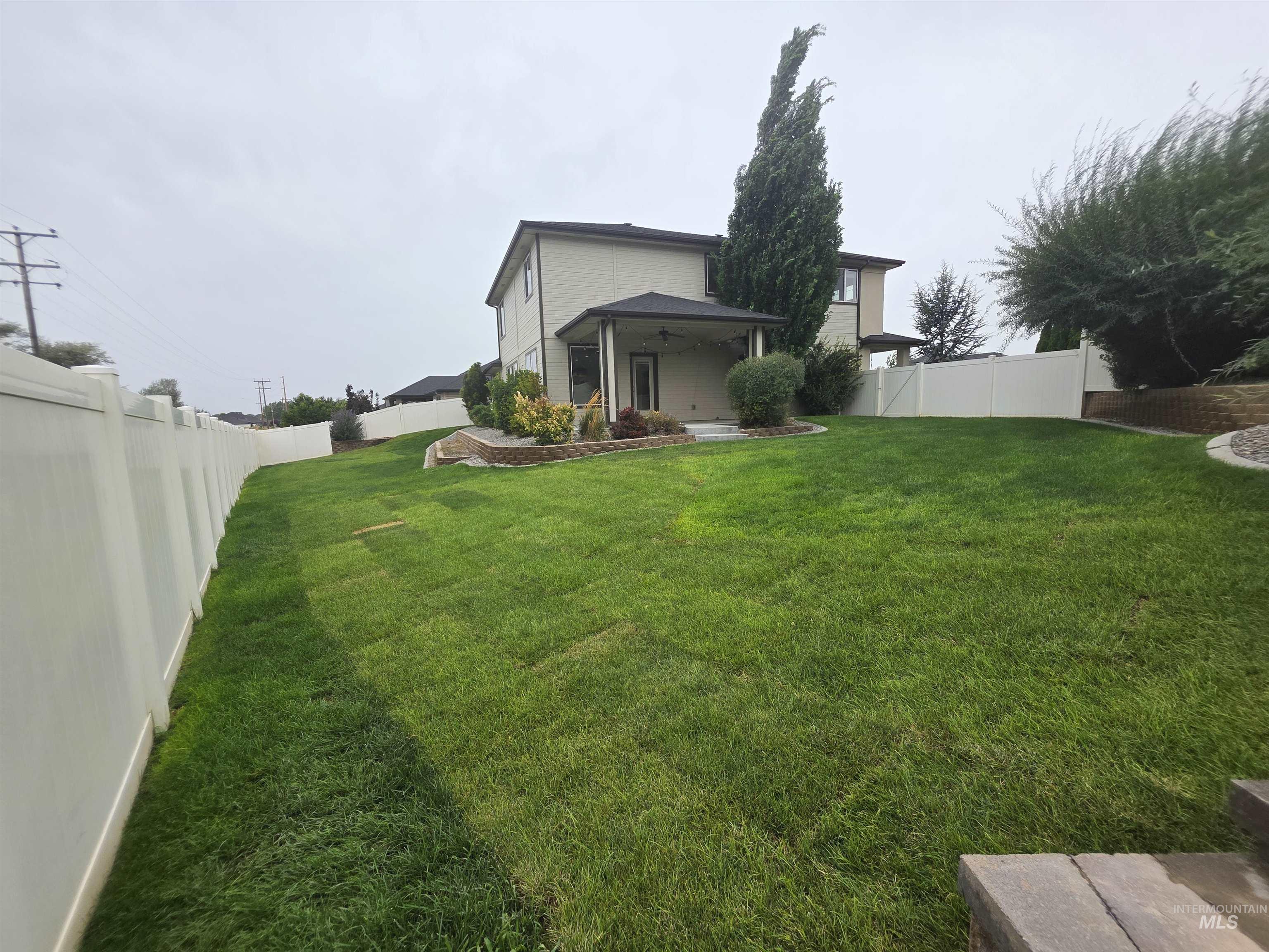 Back of house featuring a fenced backyard, a patio area, and a ceiling fan