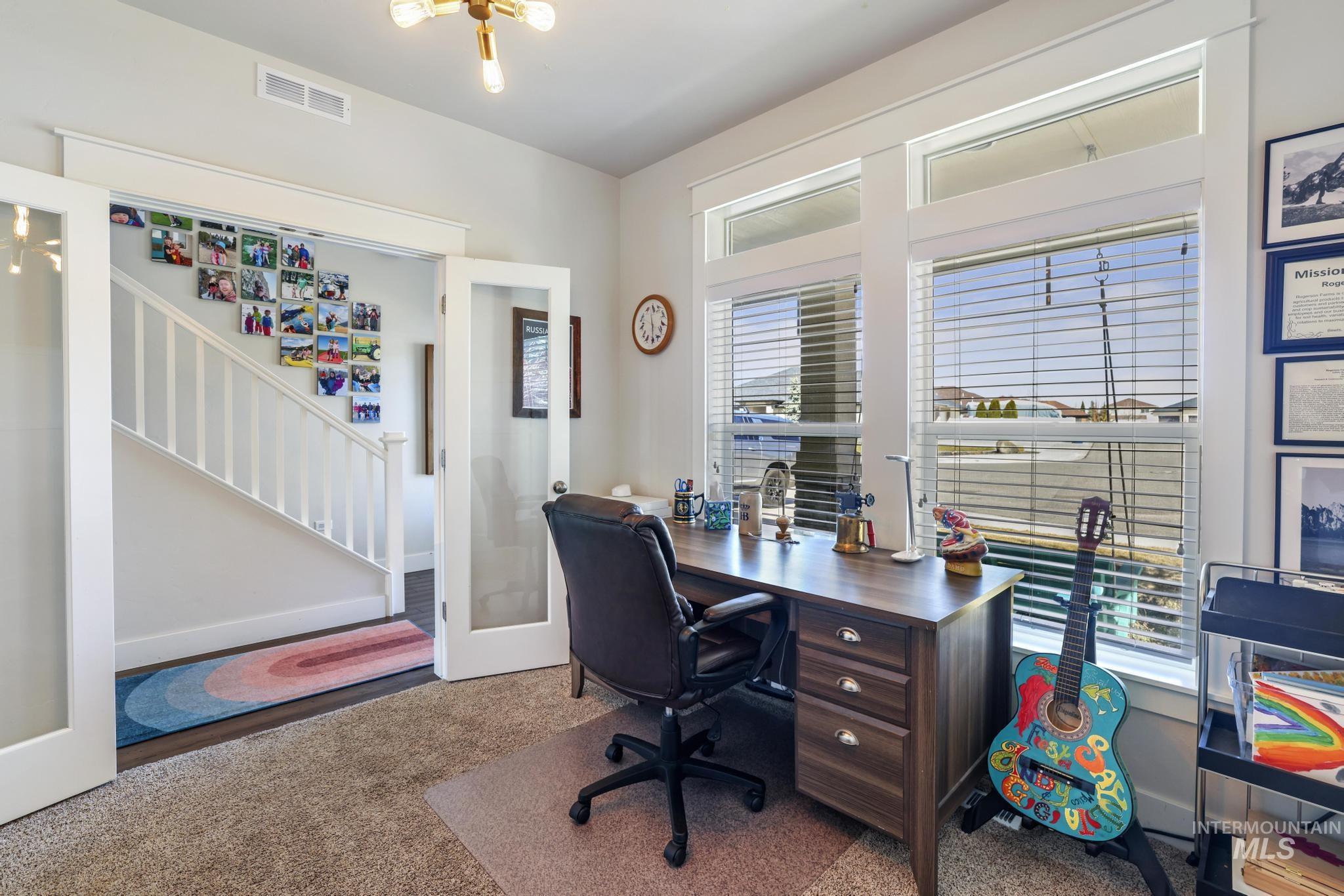Carpeted office space featuring french doors and baseboards