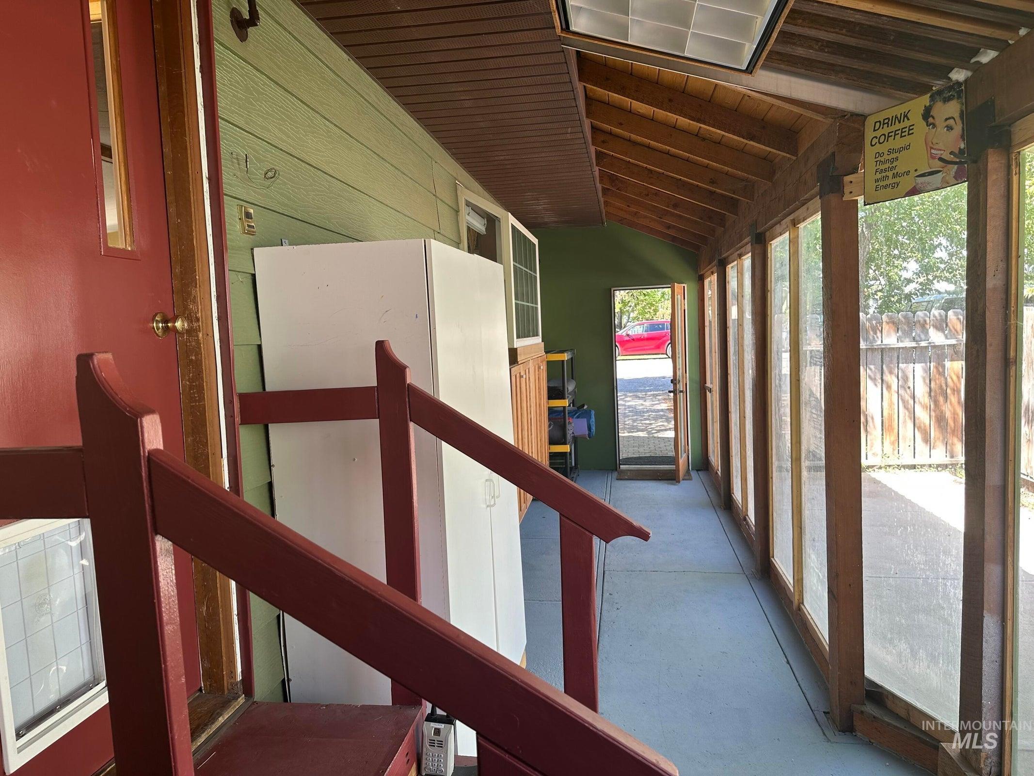 Stairs featuring vaulted ceiling, concrete floors, and wooden ceiling
