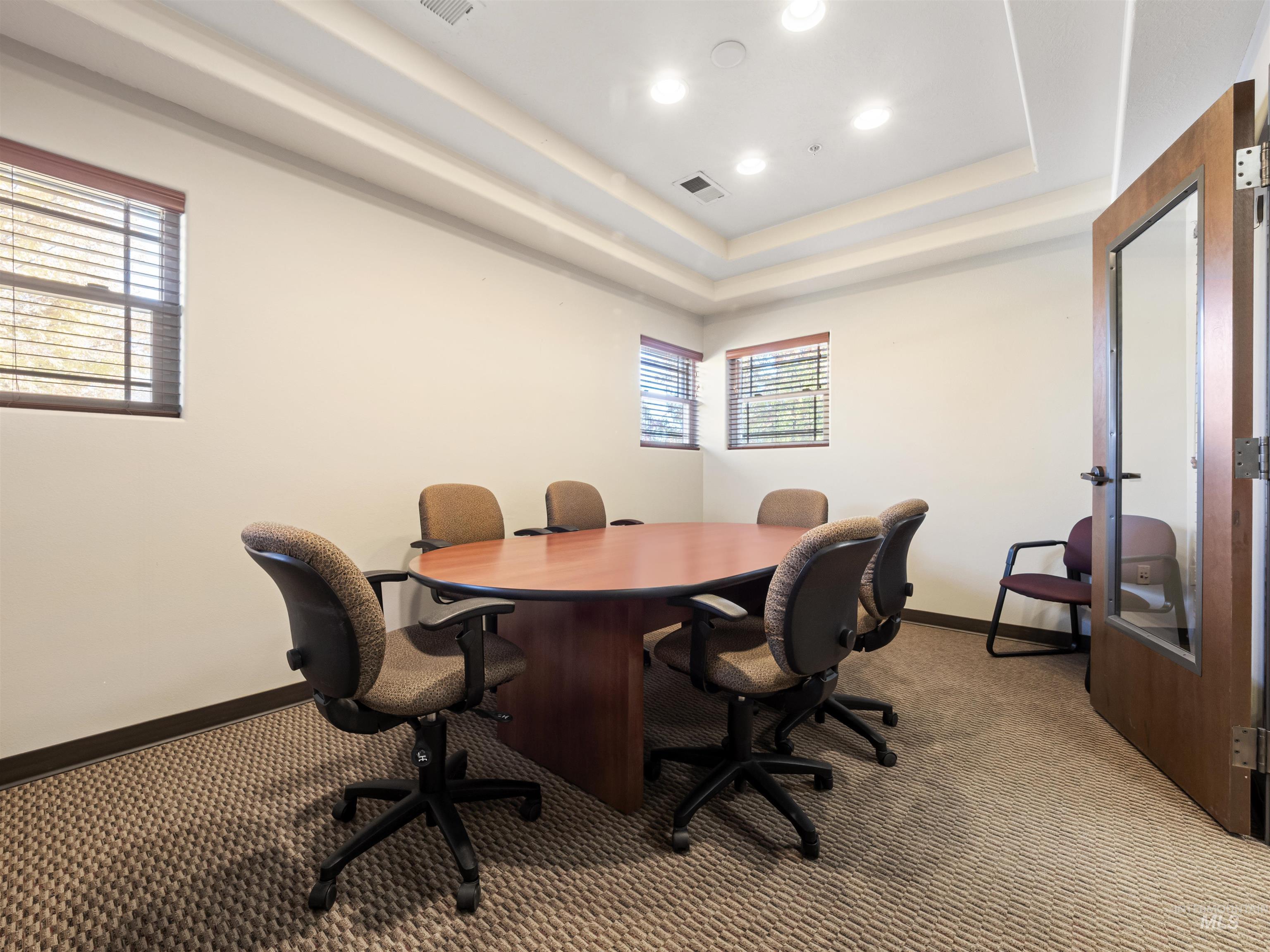 Office area with carpet flooring, recessed lighting, and a raised ceiling