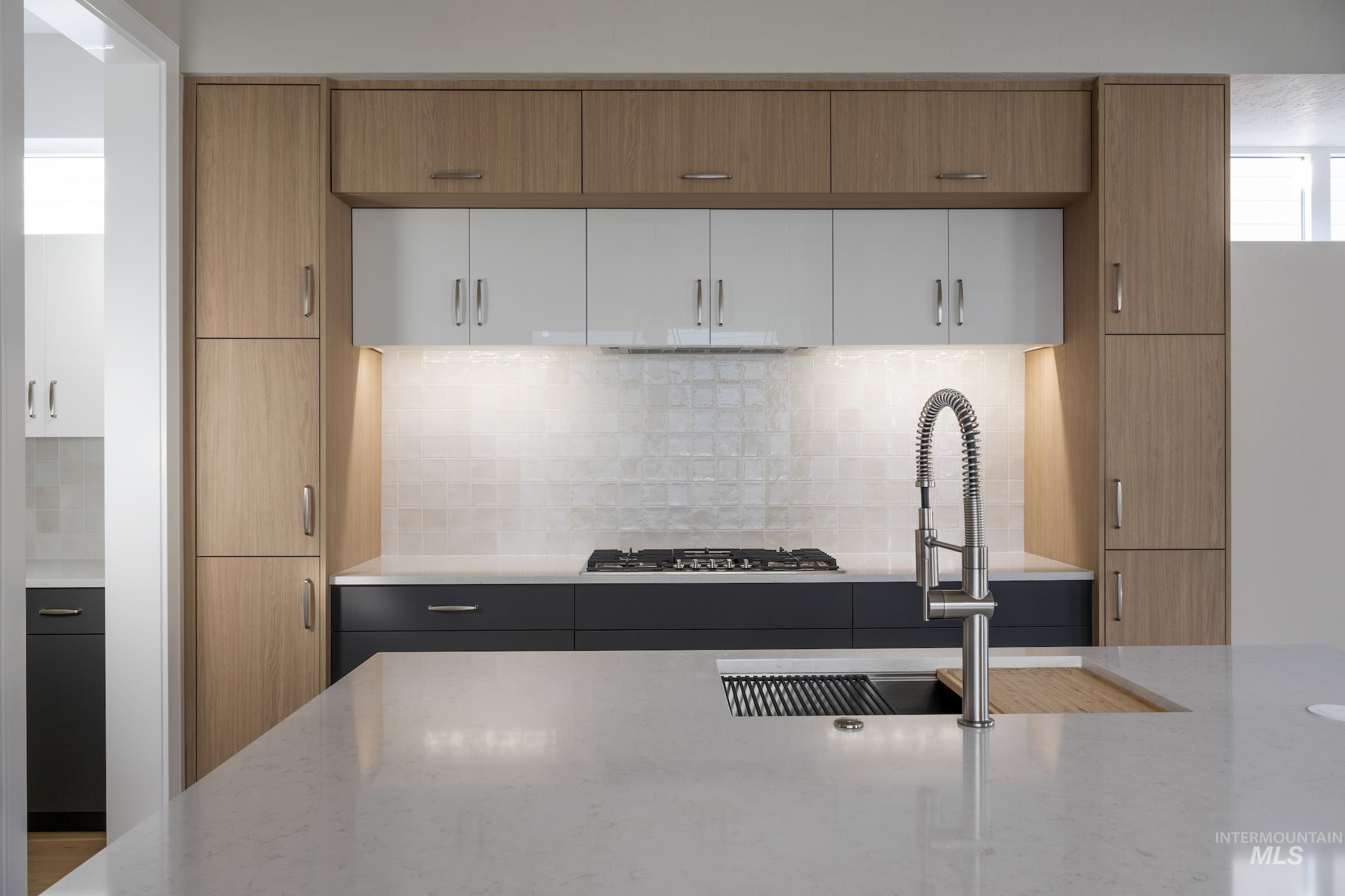 Kitchen with white cabinets, light stone counters, and modern cabinets