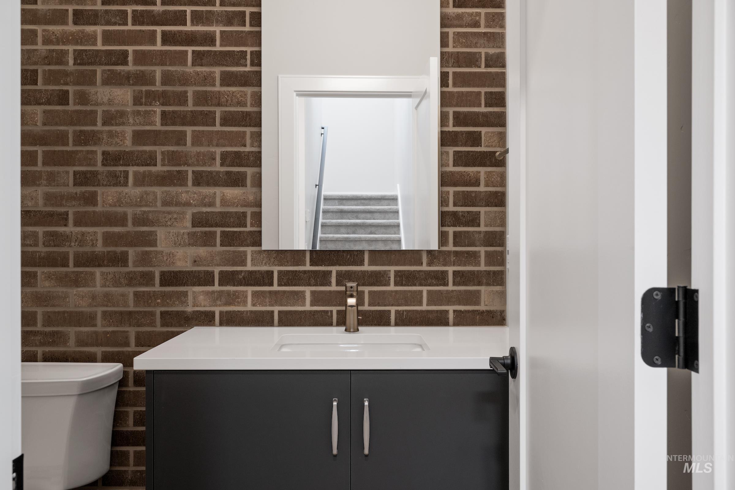 Bathroom with vanity and brick wall