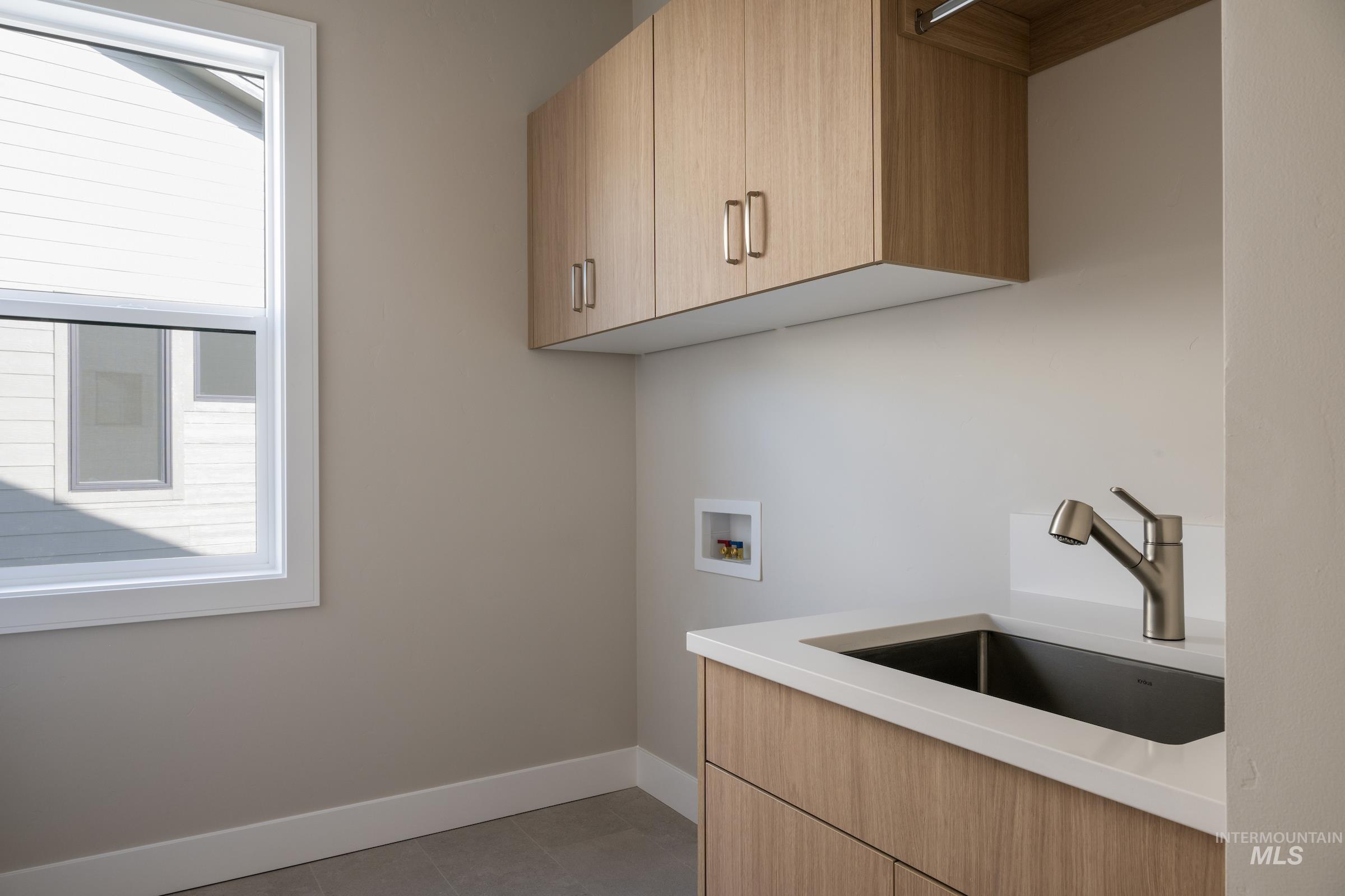 Laundry area featuring hookup for a washing machine, cabinet space, and tile patterned floors